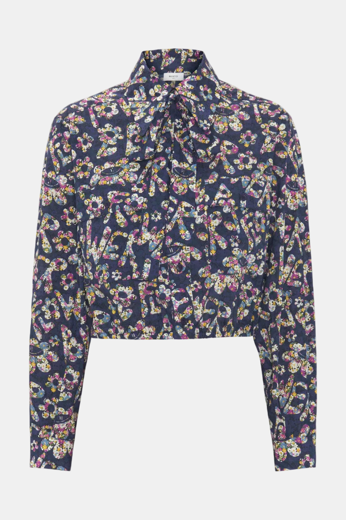 A long-sleeve cropped blouse with a dark navy blue base and an all-over multicolor floral and paisley print, featuring a pointed collar and a front tie detail, shown against a plain light gray background.