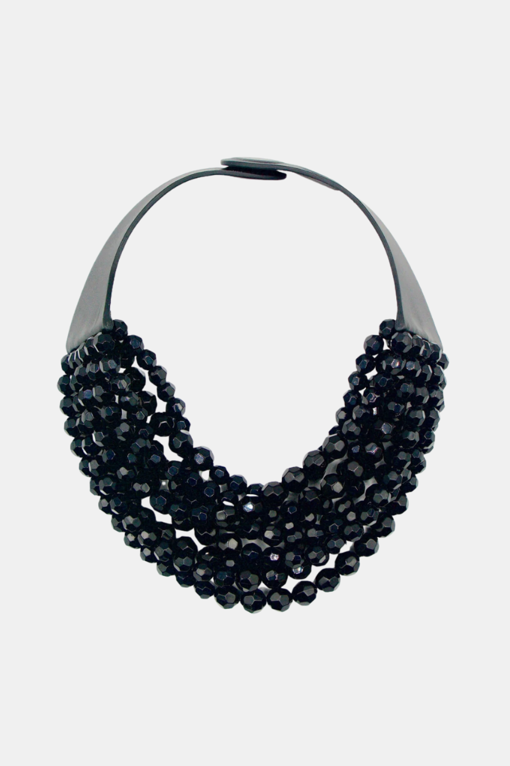A multi-strand statement necklace featuring dark, faceted beads draped over a sleek black metal band, set against a plain light gray background.