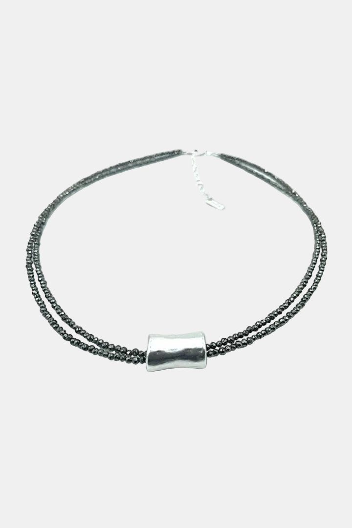 Necklace with black beads and a silver clasp on a white background