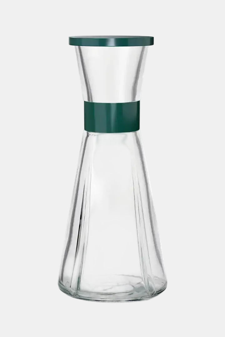 Clear glass carafe with a green lid and band on a white background
