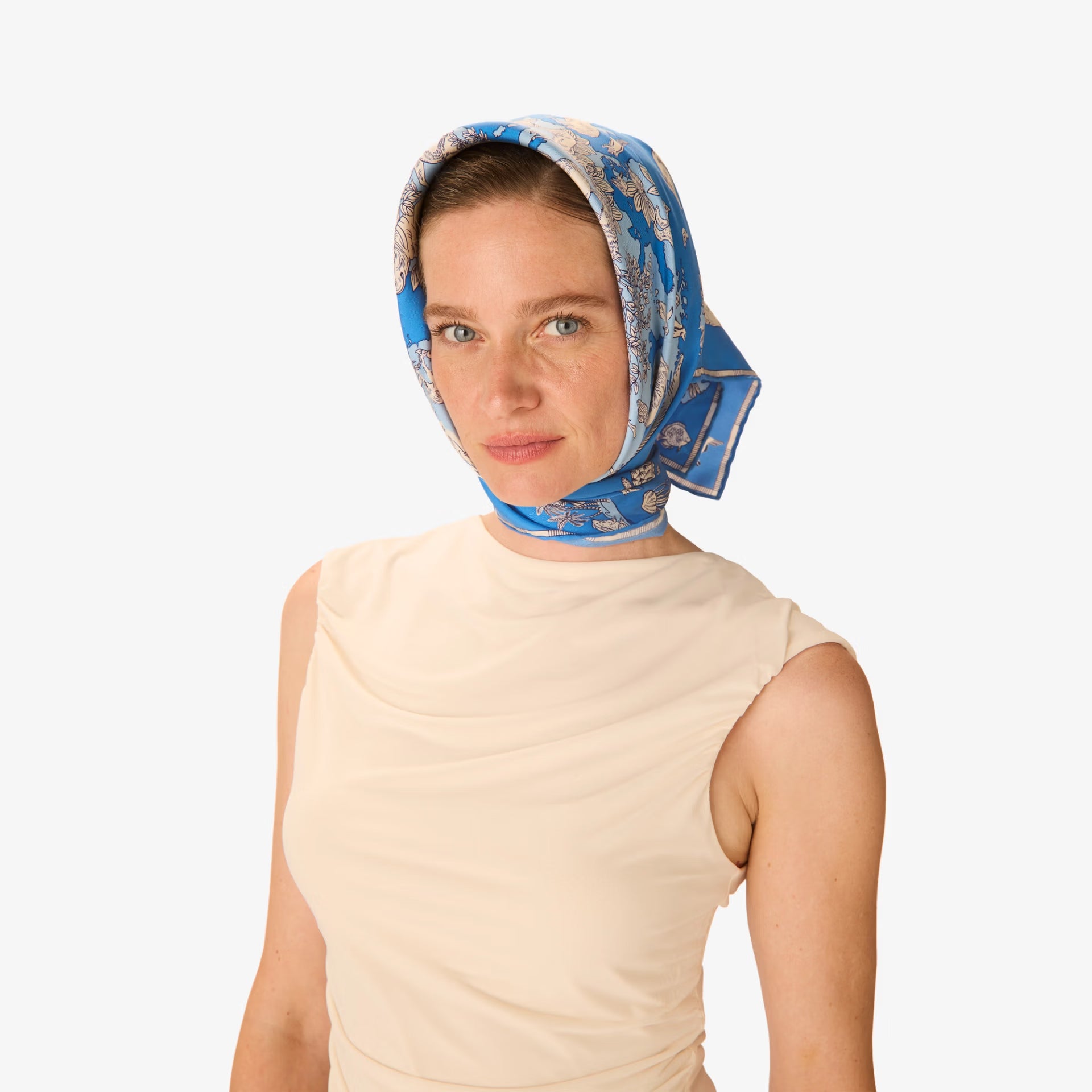Woman wearing a blue patterned headscarf on a white background
