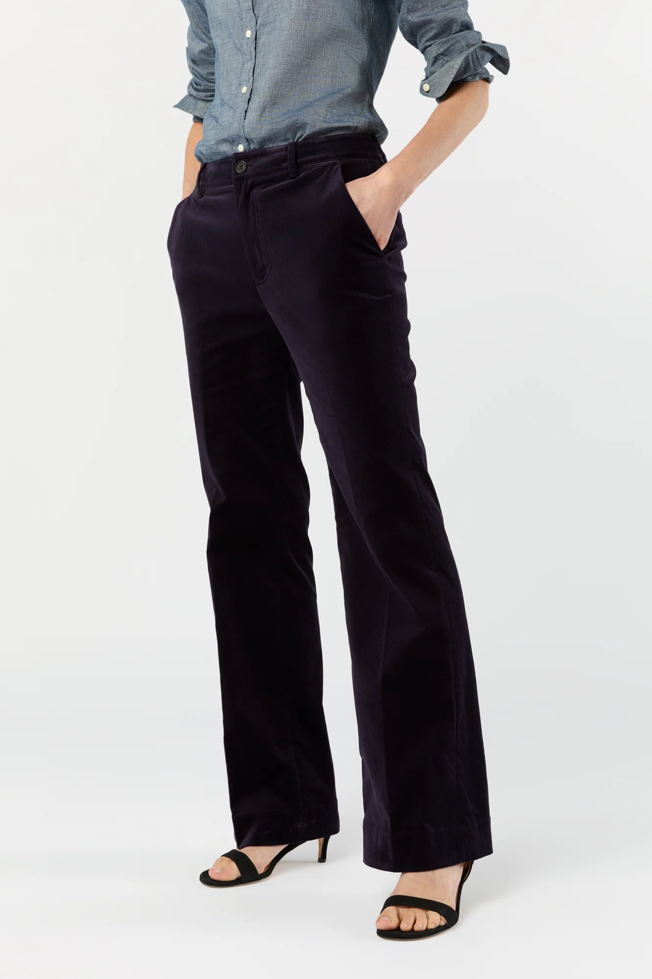 Person wearing black pants and a light blue shirt on a white background