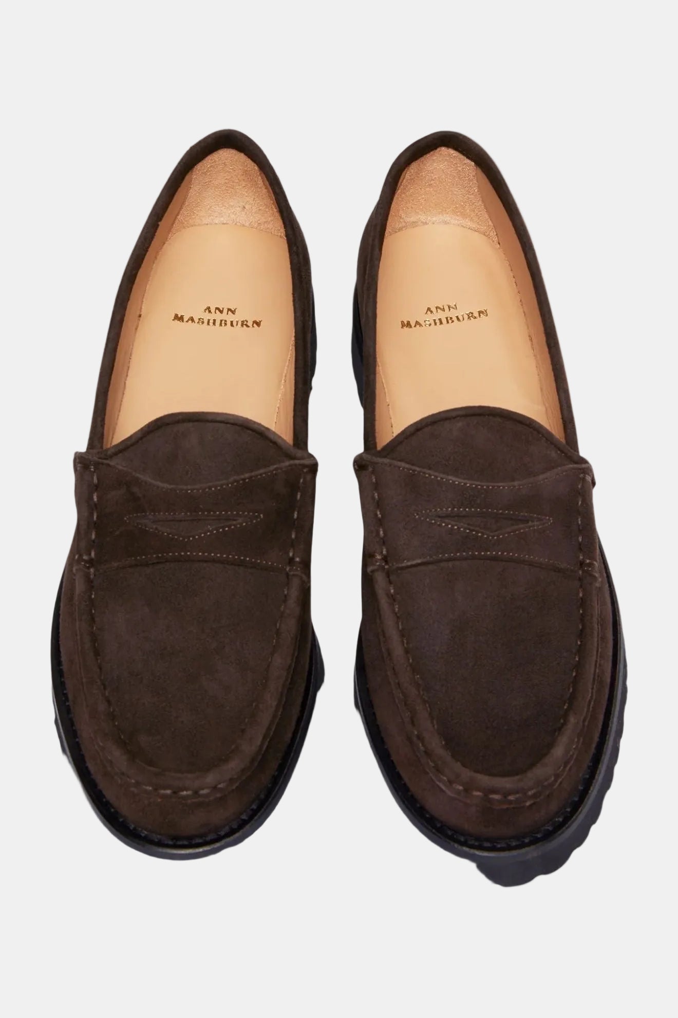 A pair of navy blue suede loafers with a lug sole.