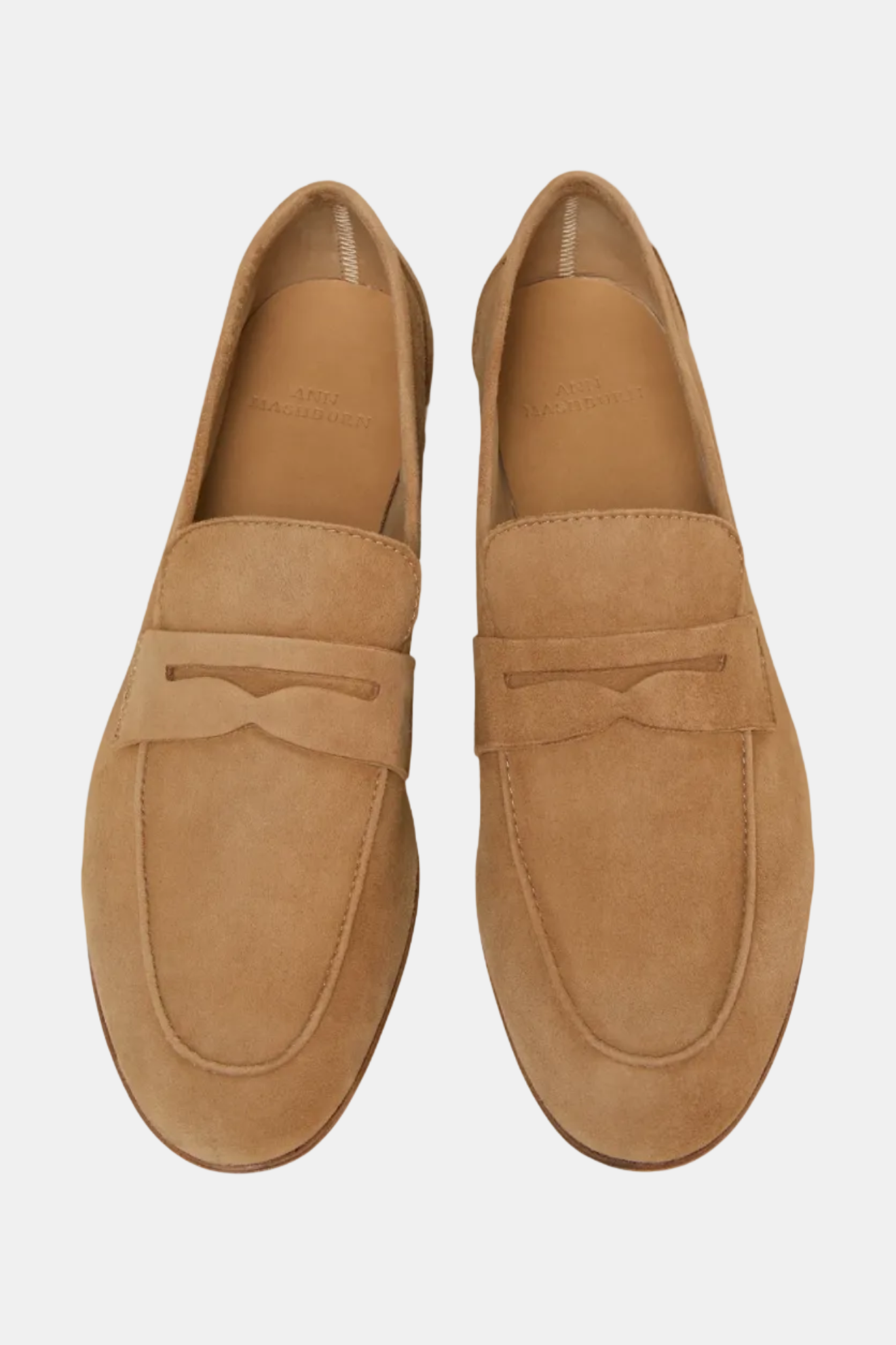 A single camel-colored unlined suede penny loafer shoe.
