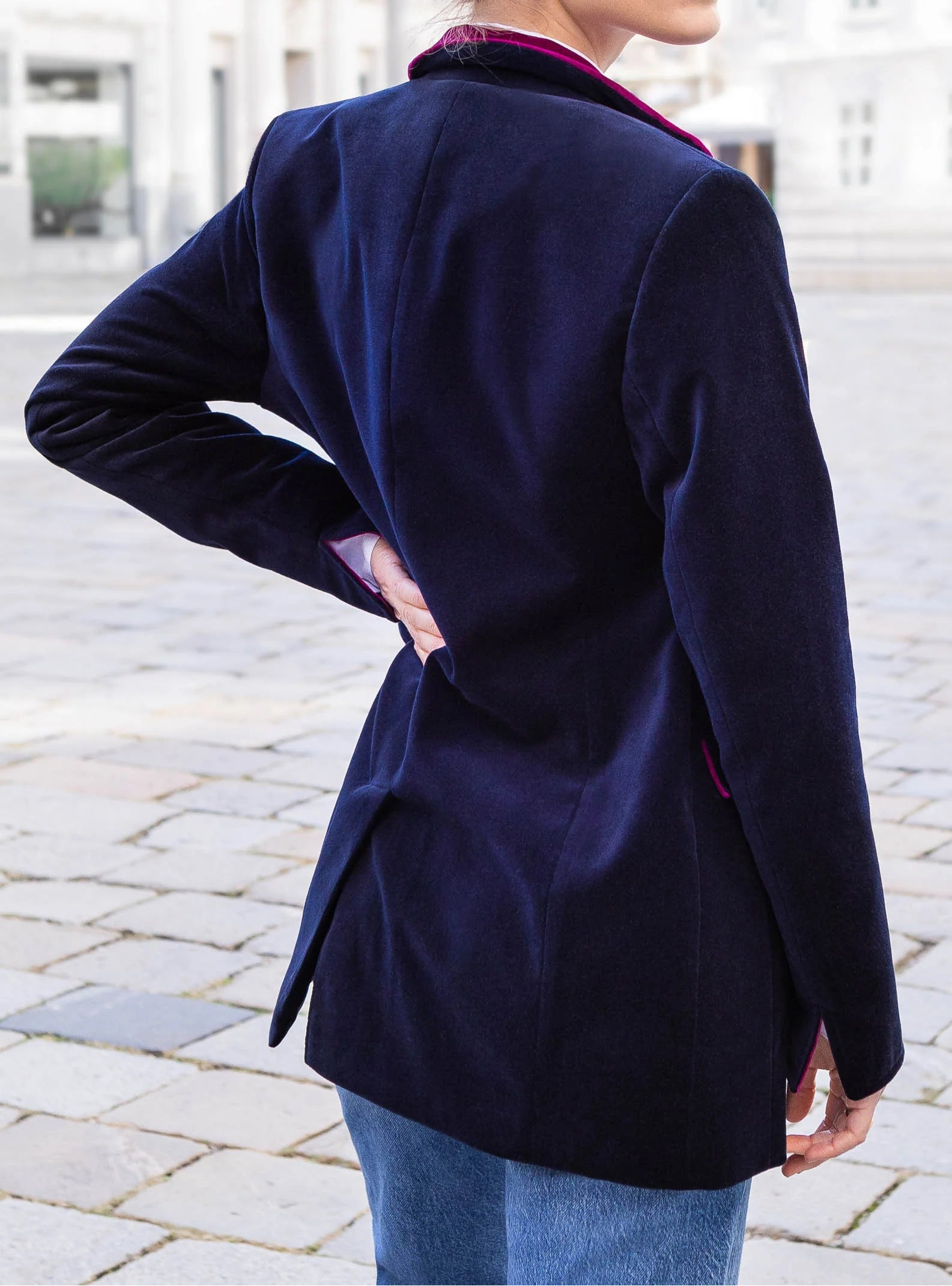 Woman wearing a navy blue blazer with a blurred background