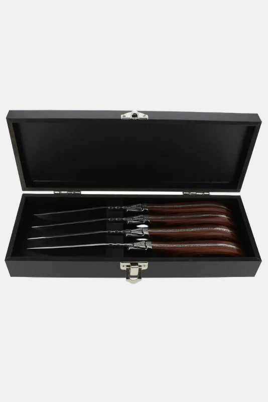 Set of four steak knives with wooden handles in a black case on a white background