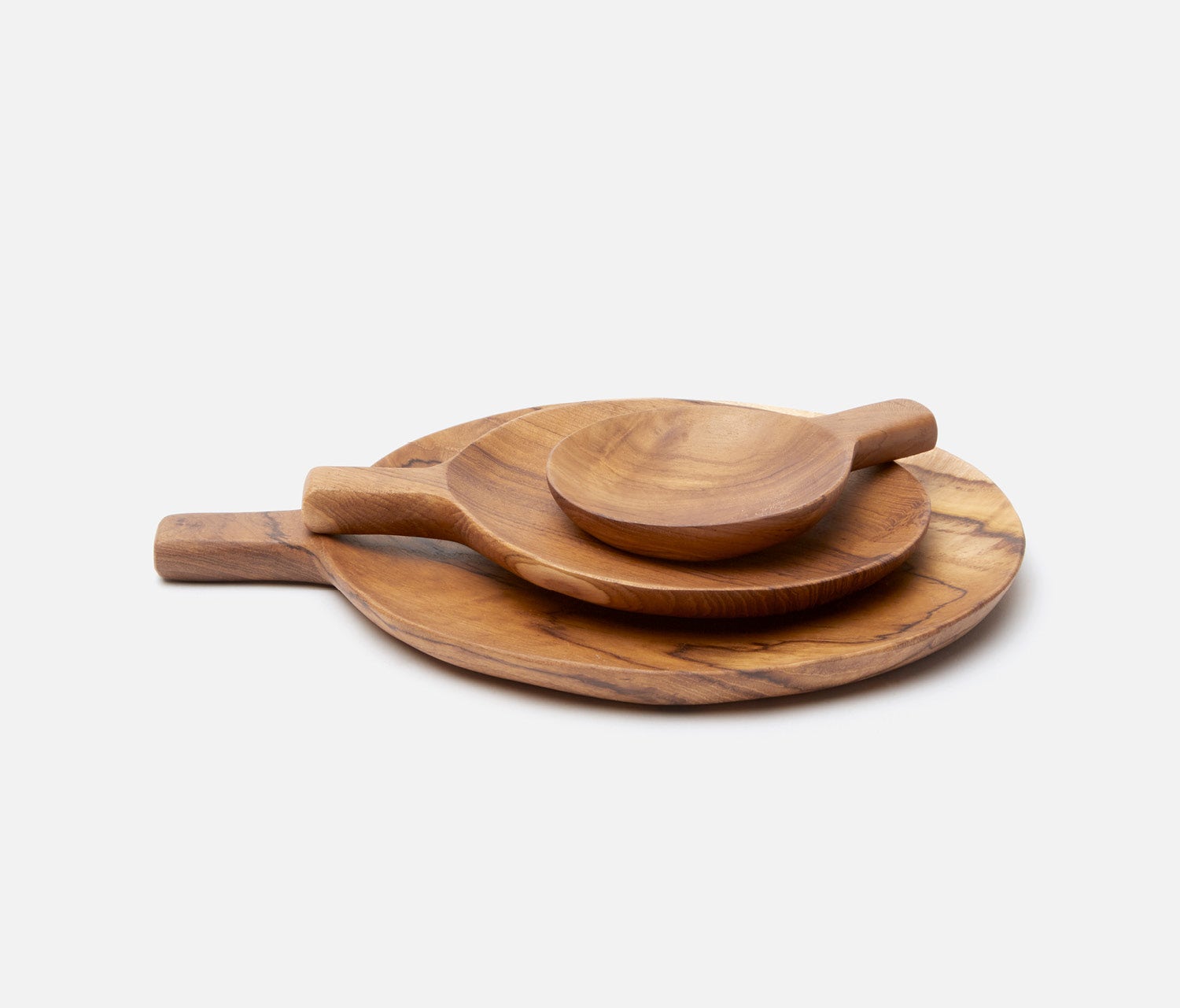 A set of handcrafted olive wood serving pieces, including a large round platter with a handle, a smaller matching platter, a wooden spoon, and a small bowl, arranged on a light gray background.