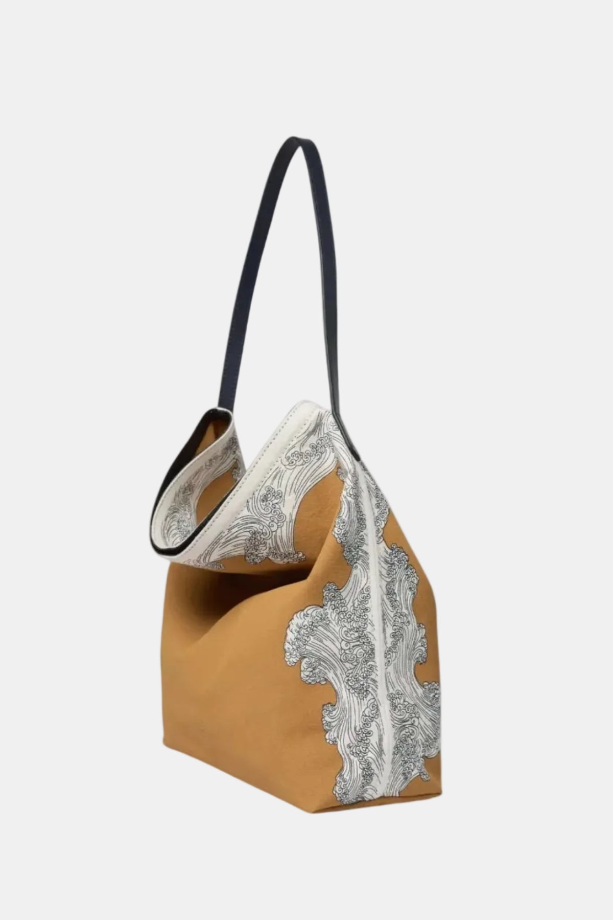 A slouchy shoulder bag with a mustard yellow body, a white and gray paisley patterned front panel, and a black shoulder strap, shown against a plain white background.