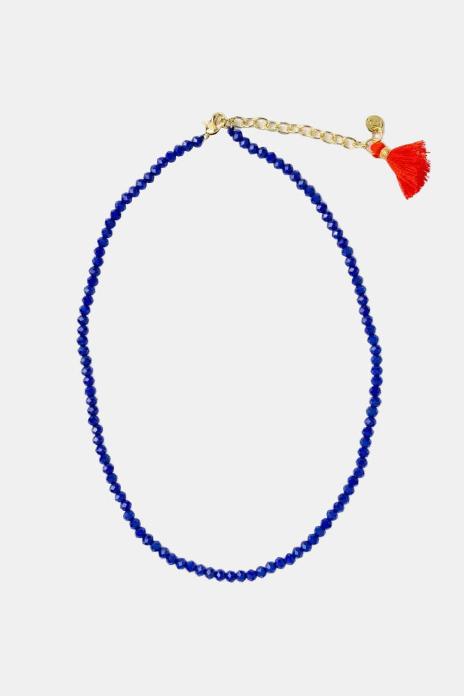 Blue beaded necklace with a red tassel on a white background
