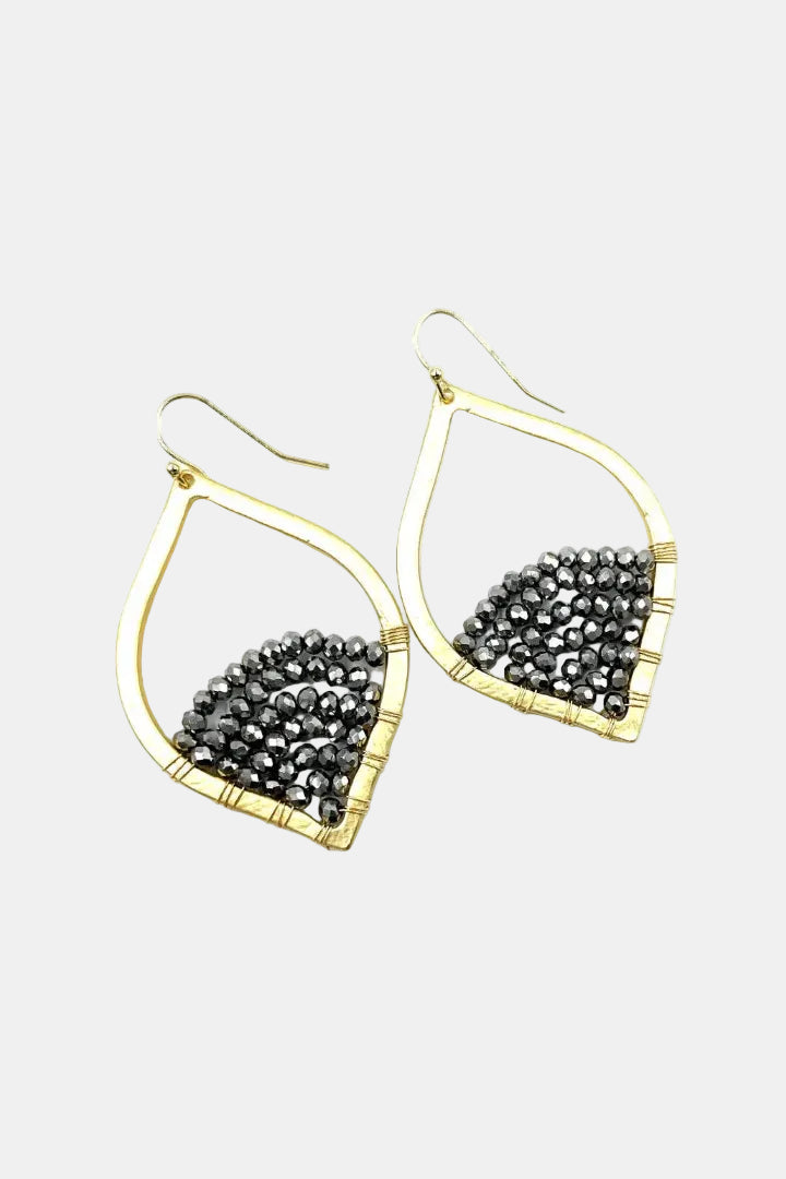 Gold-framed earrings with black gemstones on a white background