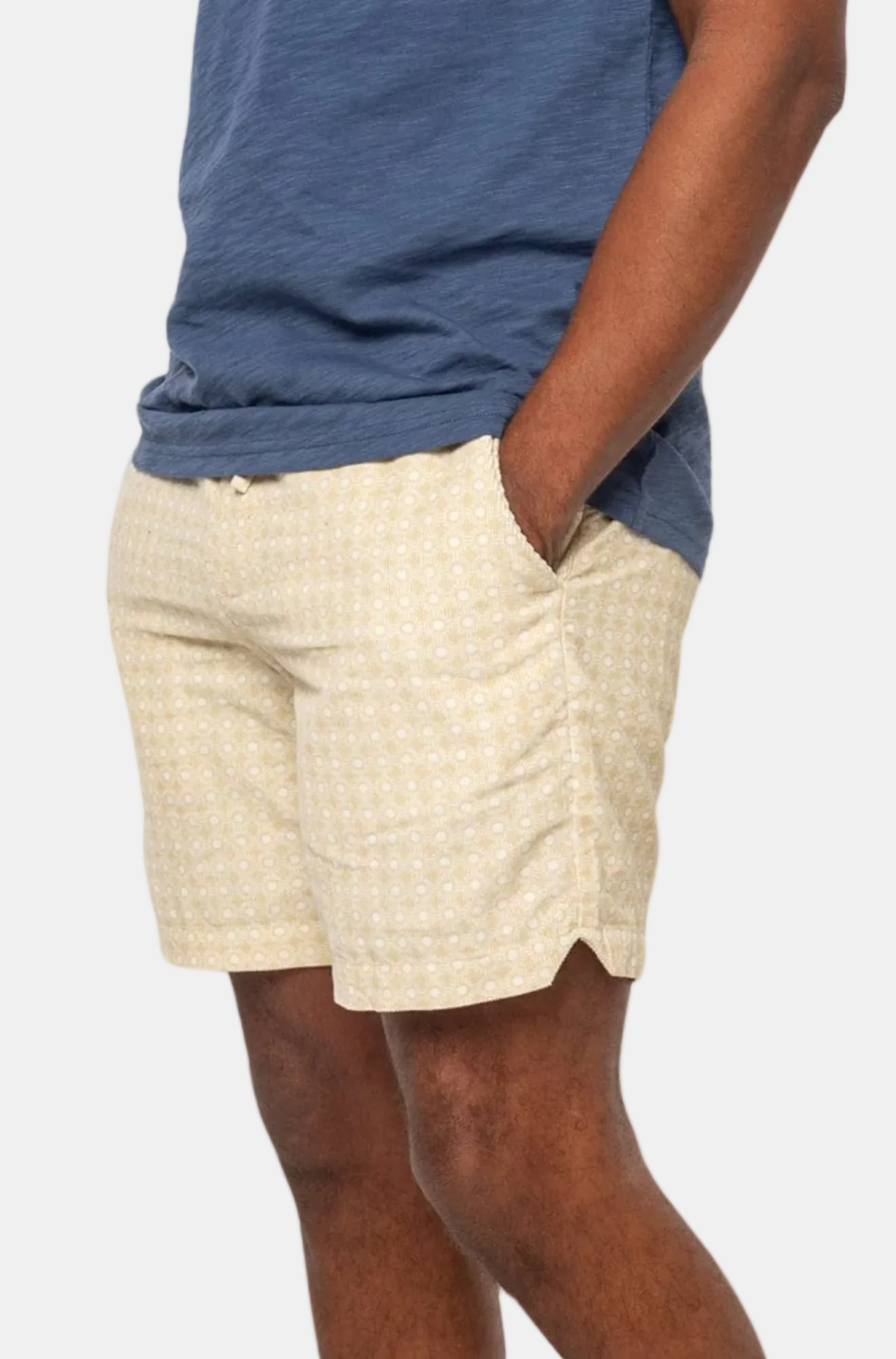 A person wearing beige corduroy shorts with an elastic waistband.
