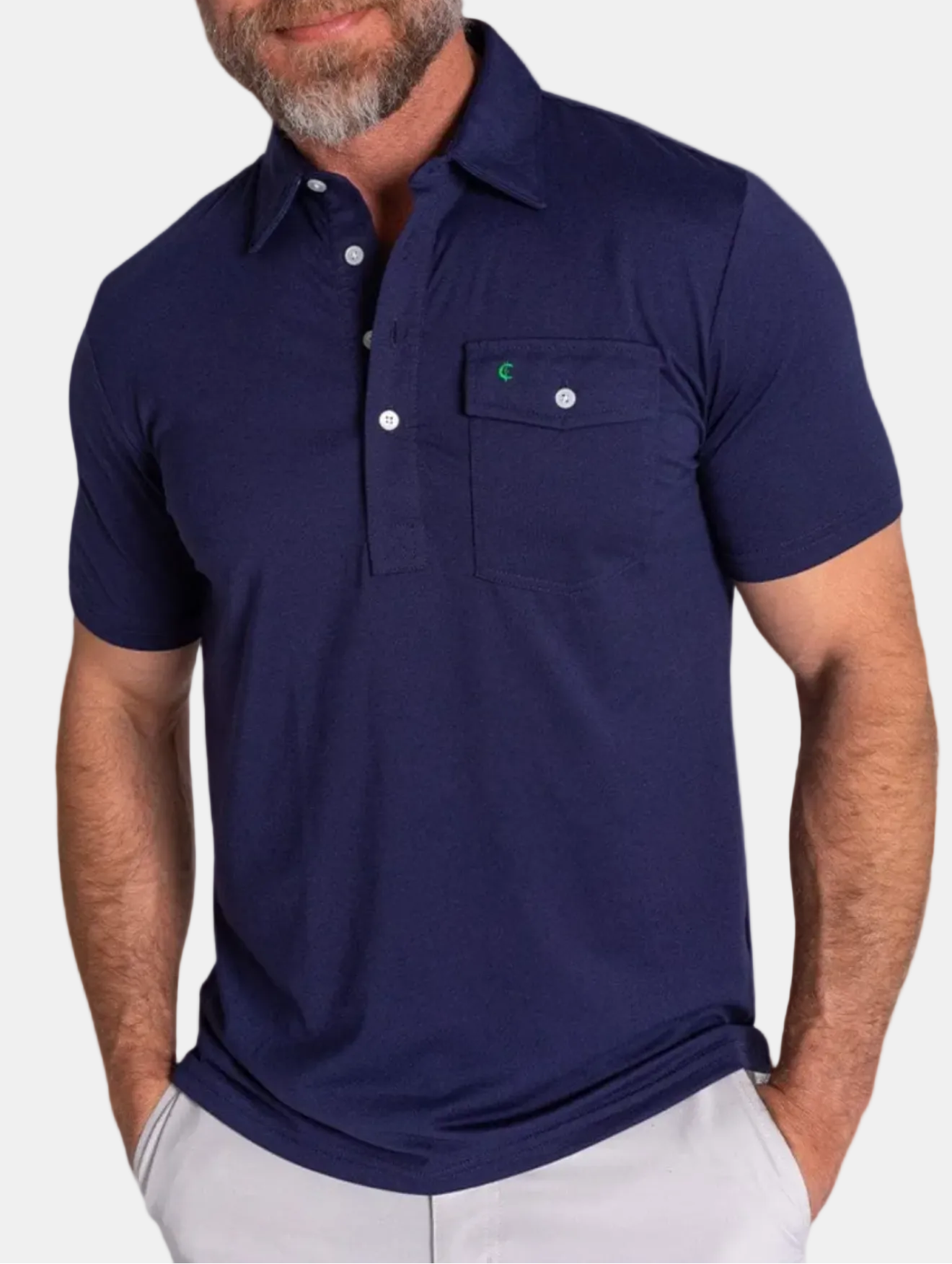 Man wearing a navy blue polo shirt with a green logo on a white background