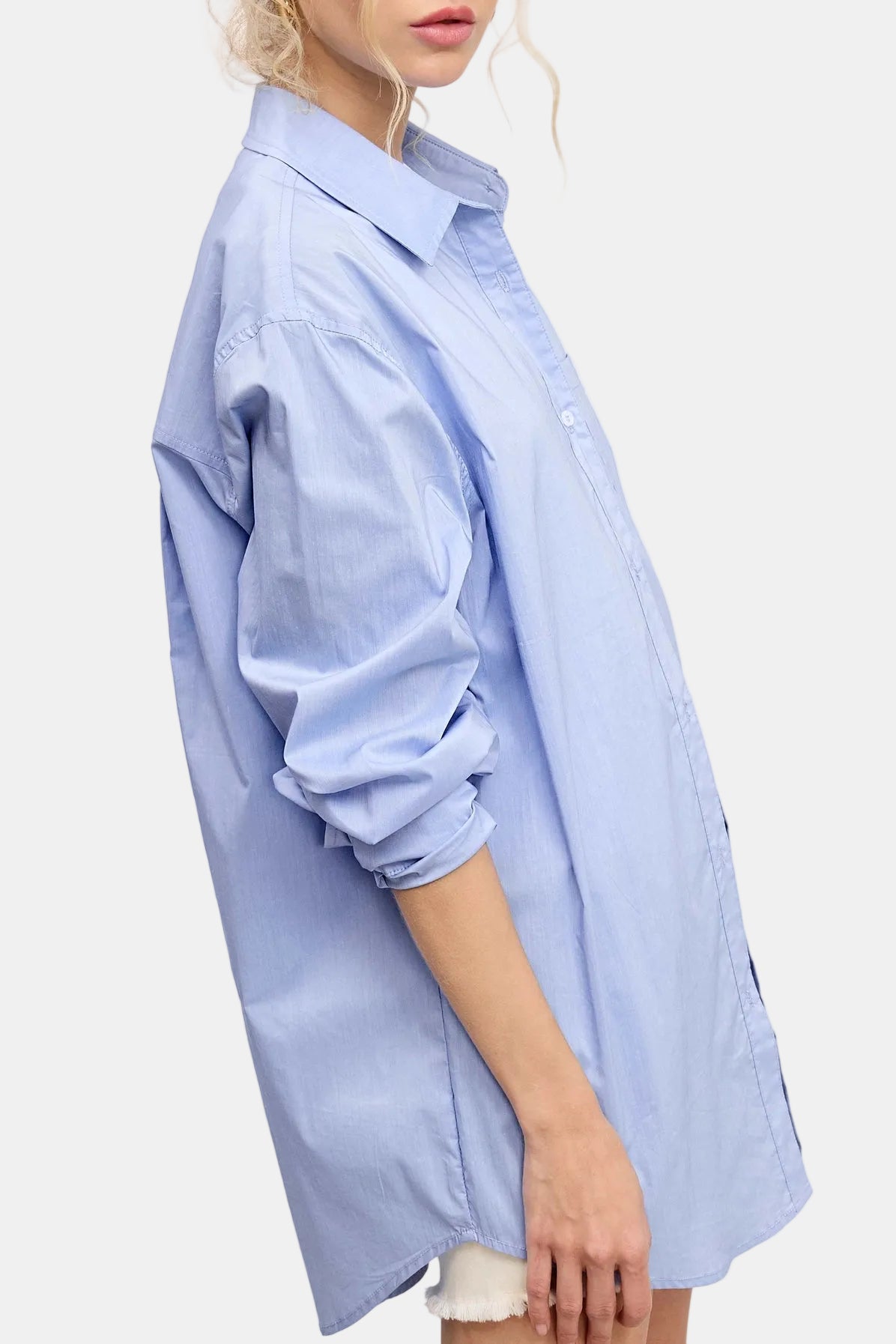 Light blue oversized shirt worn by a person on a light pink background