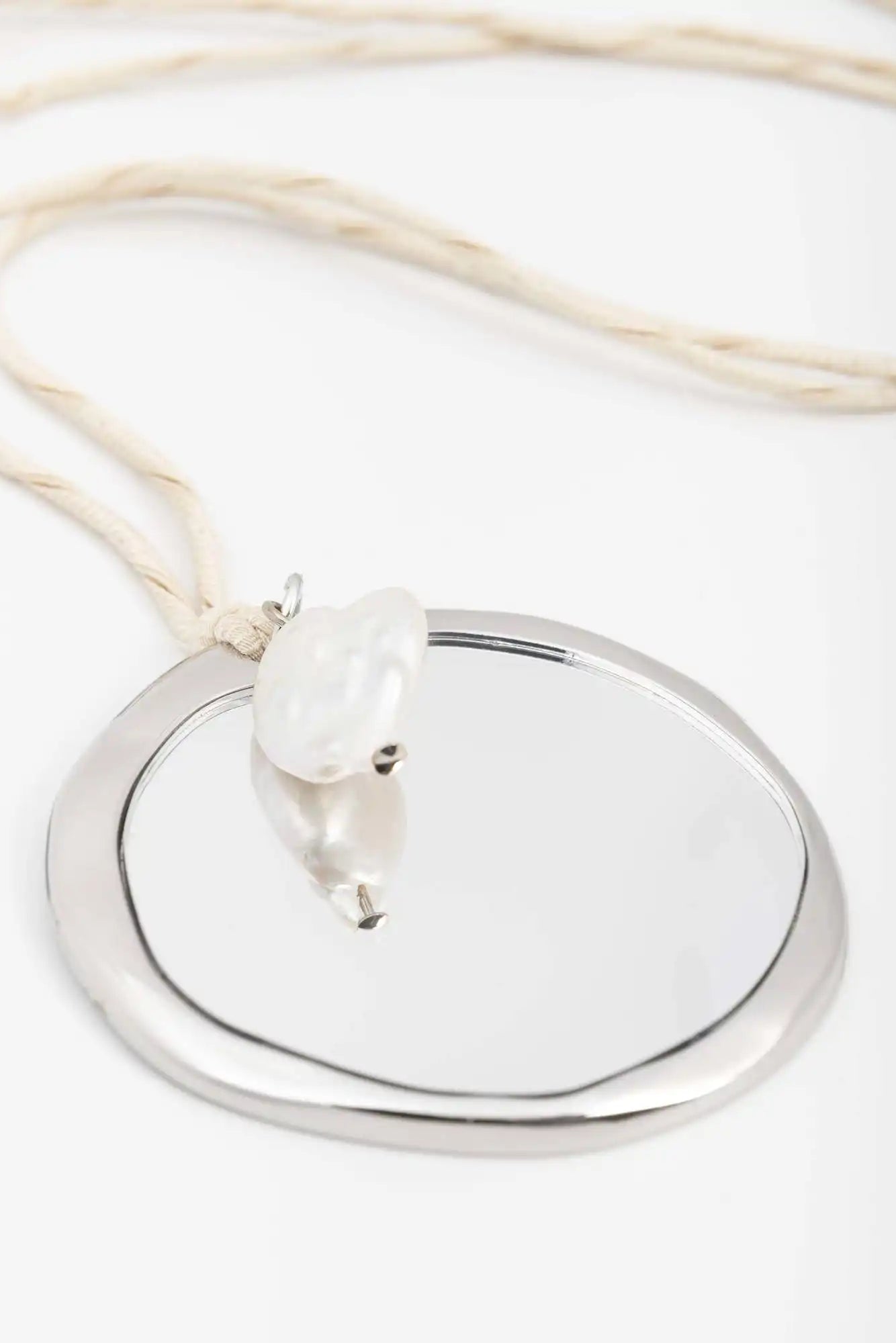 Silver pendant with a pearl on a white background