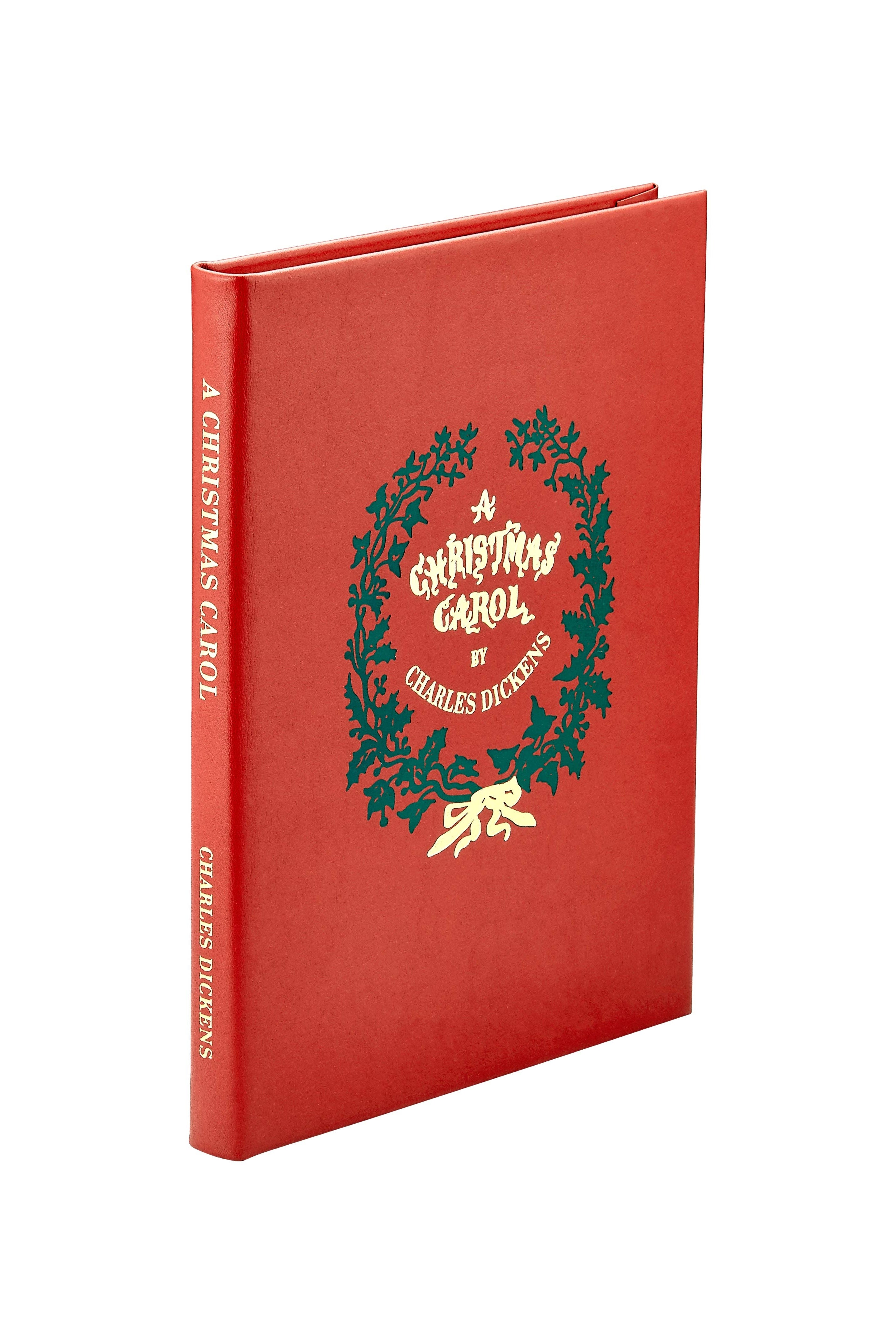 Red book titled 'A Christmas Carol' by Charles Dickens with a green wreath design on the cover.