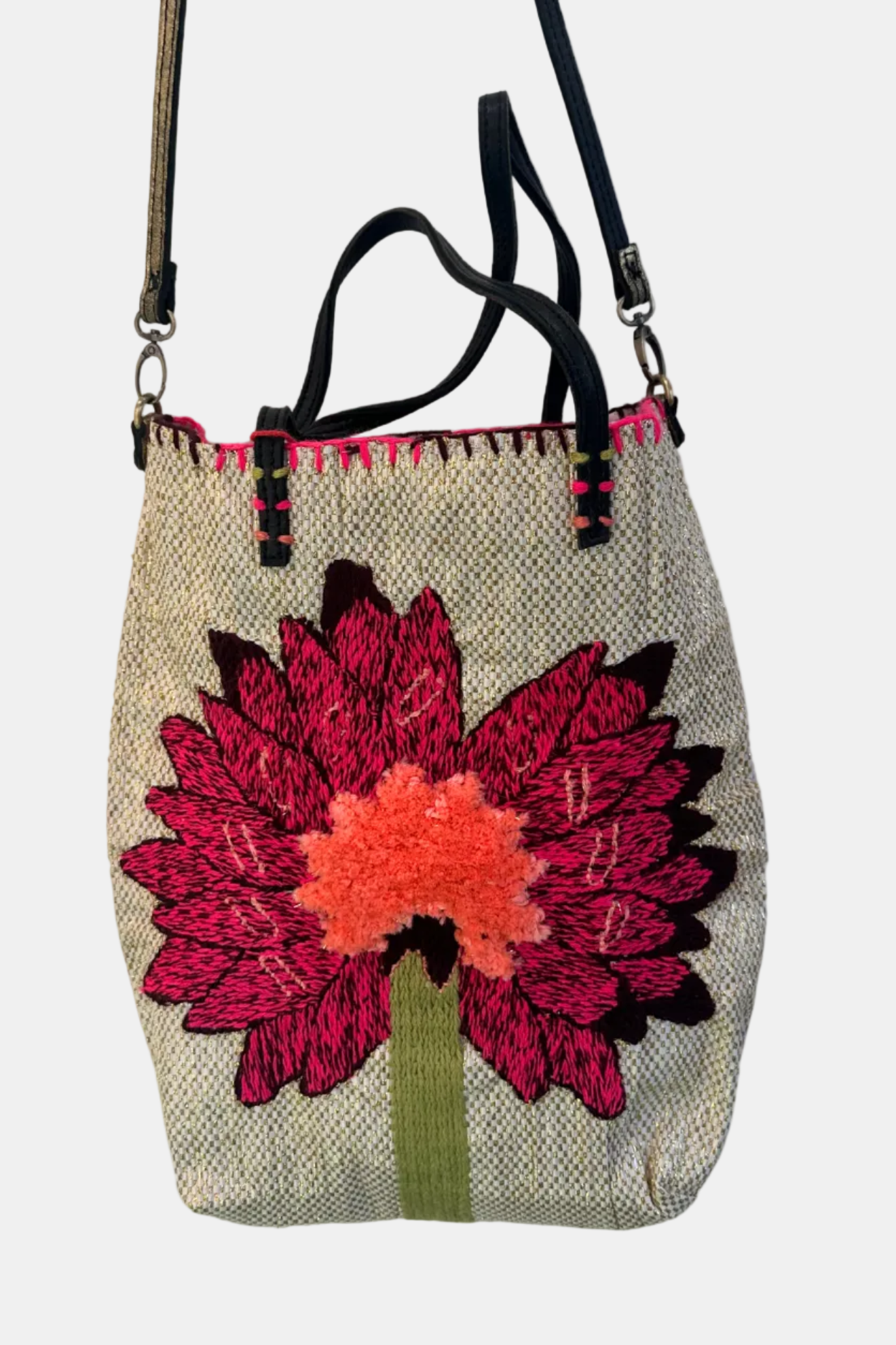 A handcrafted tote bag with a geometric pattern featuring a stylized face design in blue and white, with a red mouth, on a white background. The bag has fringes and is equipped with a brown leather strap.