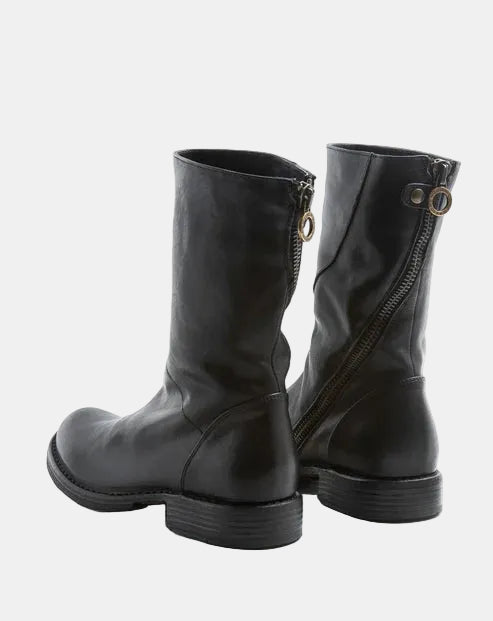 Pair of black leather boots with zipper details on a white background