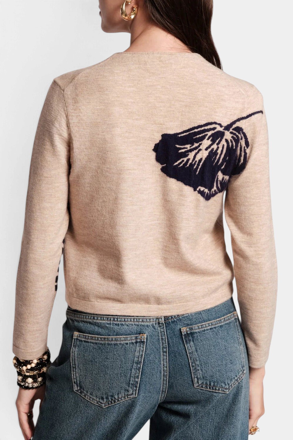 Frances Valentine Darling cardigan in beige merino wool with a dark floral print on the back, worn with blue jeans.