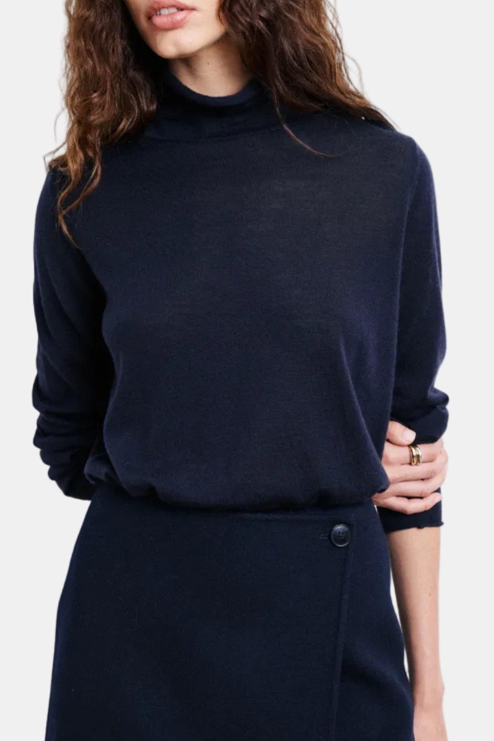 Woman wearing a dark blue turtleneck sweater on a white background