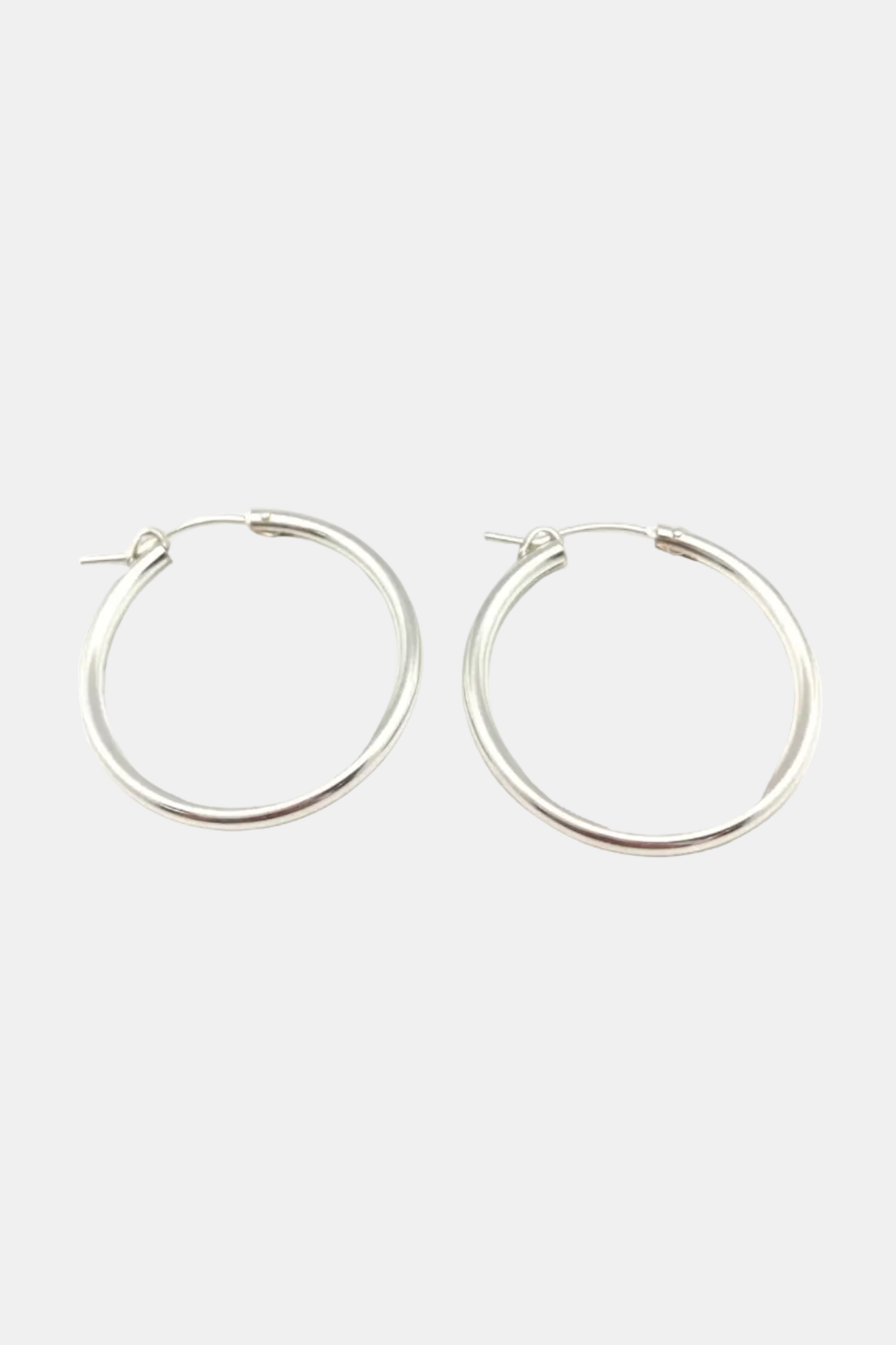 Pair of silver hoop earrings on a white background