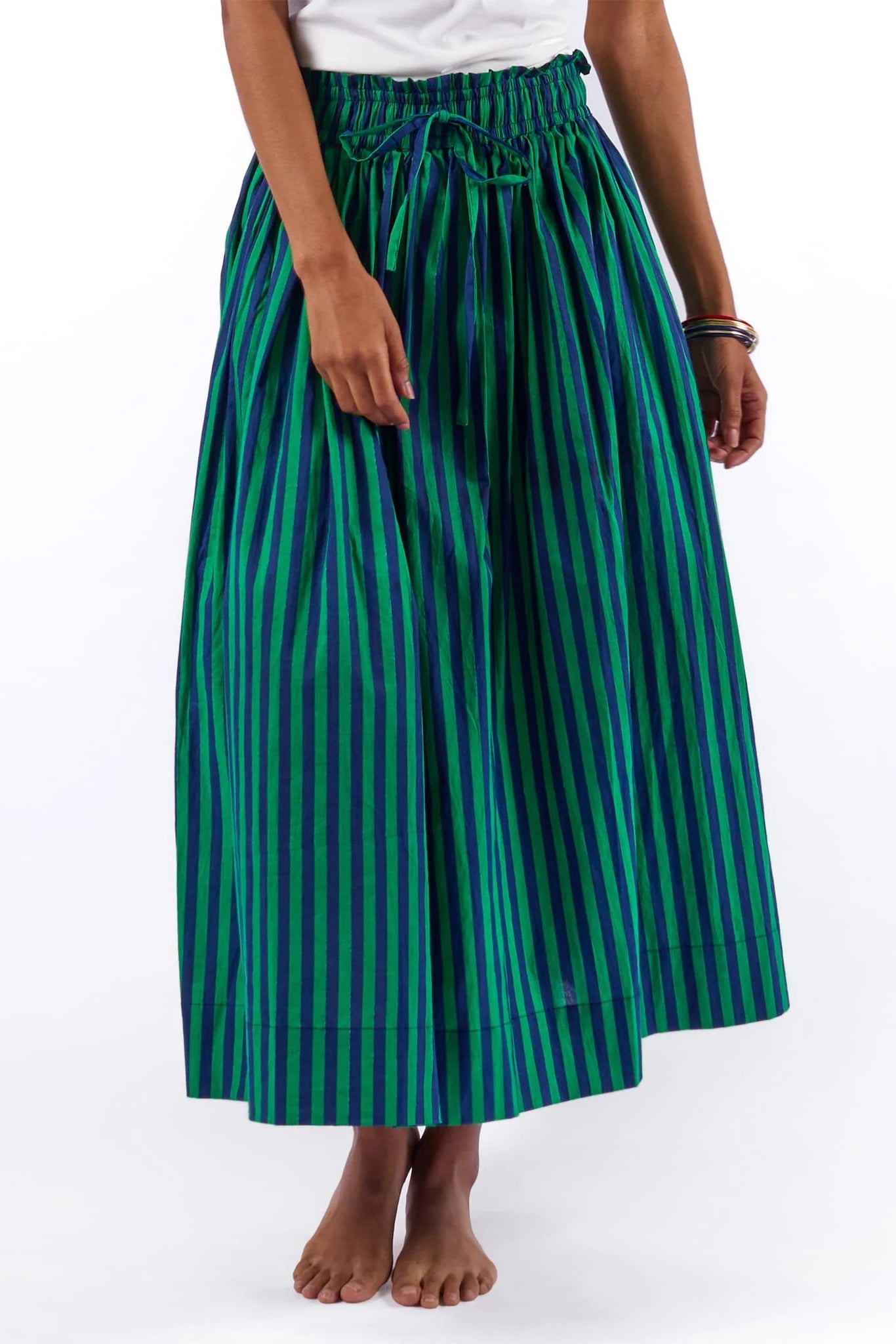 Person wearing a green and blue striped skirt on a white background