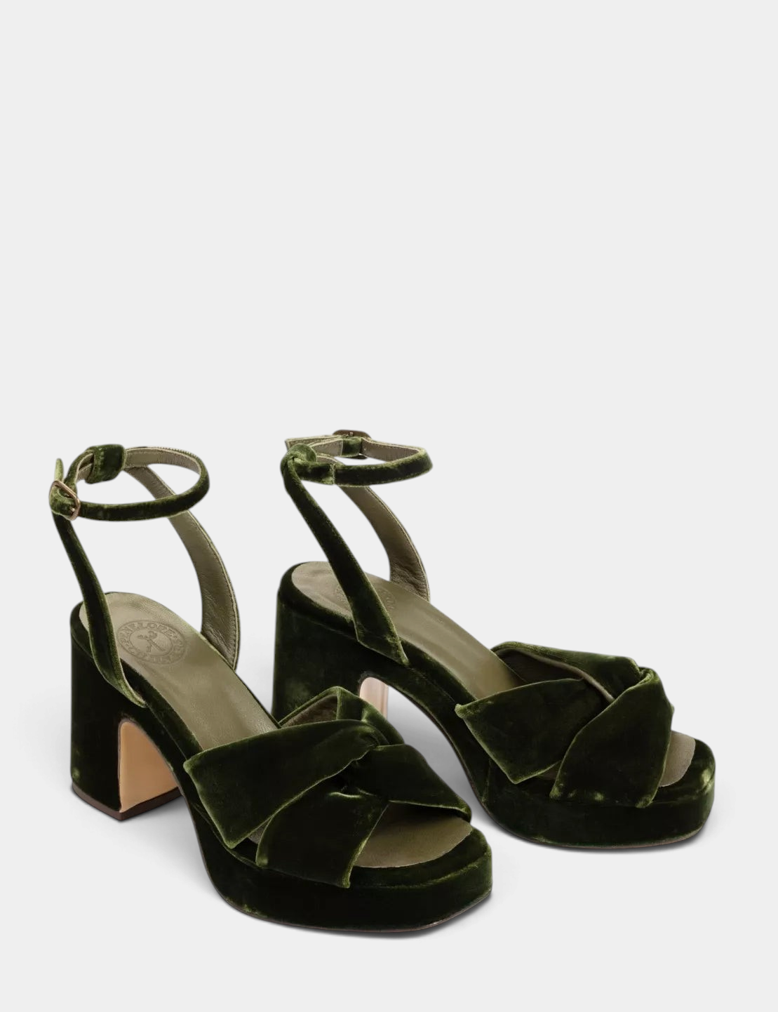 Green velvet high-heeled shoes on a white background
