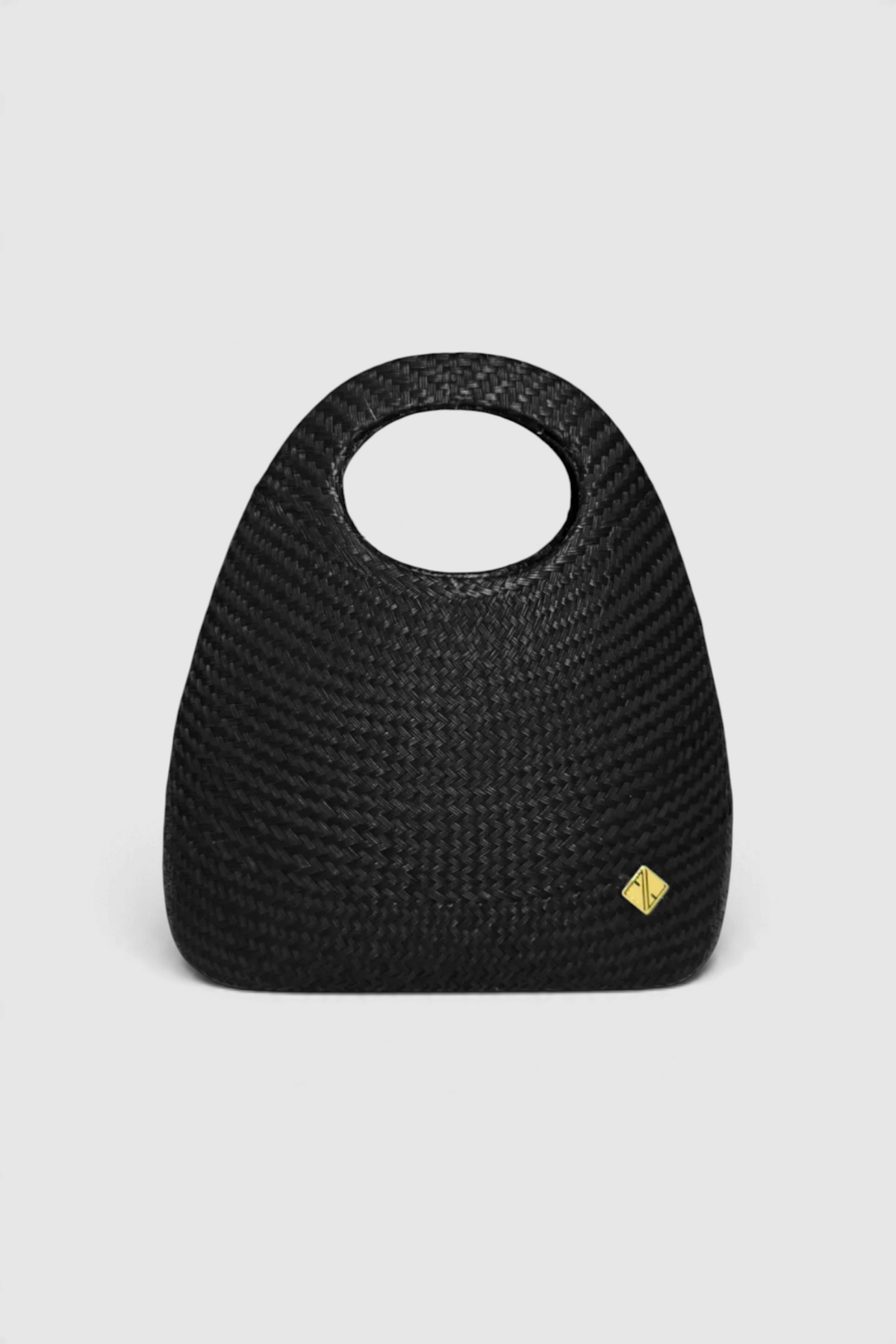 The Copper Shed Amor 1 black Tnalak woven handbag with a circular cutout handle and gold logo detail.