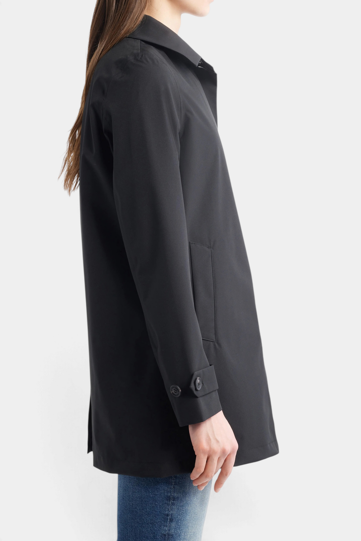 The Copper Shed April hooded black raincoat featuring a pointed collar, side pockets, and buttoned cuffs on a model.
