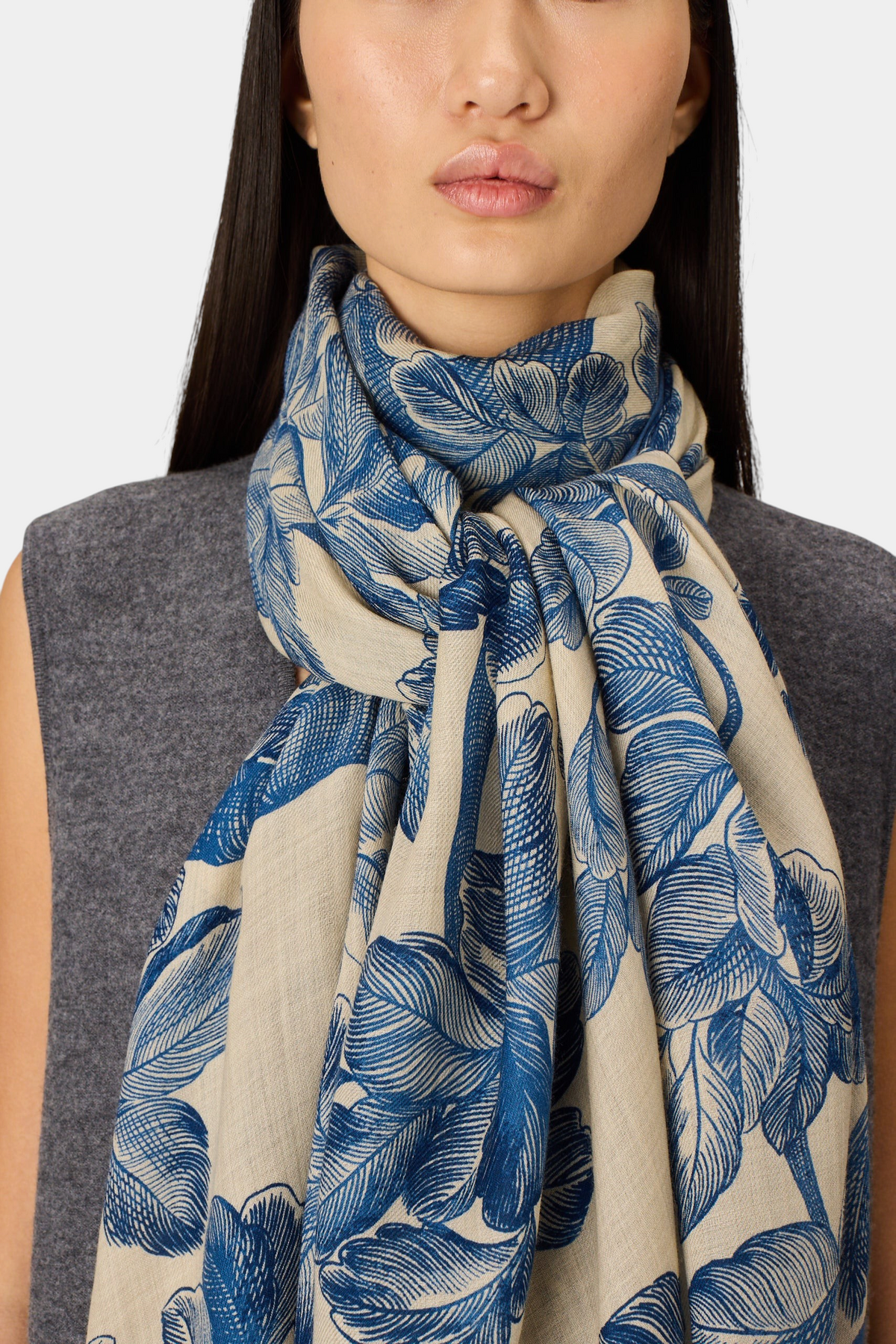 The Copper Shed Arboris blue and beige floral print wool scarf worn around a model's neck