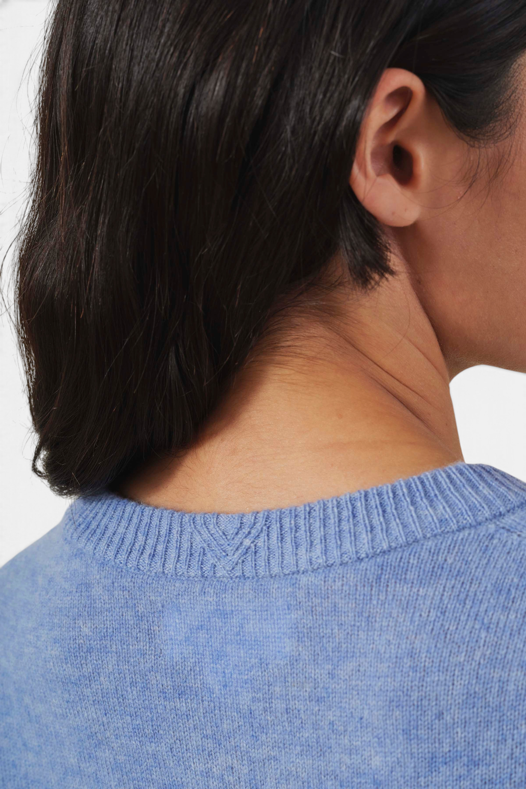 The Copper Shed Aylina blue cashmere cardigan featuring a ribbed crew neckline and soft knit texture.
