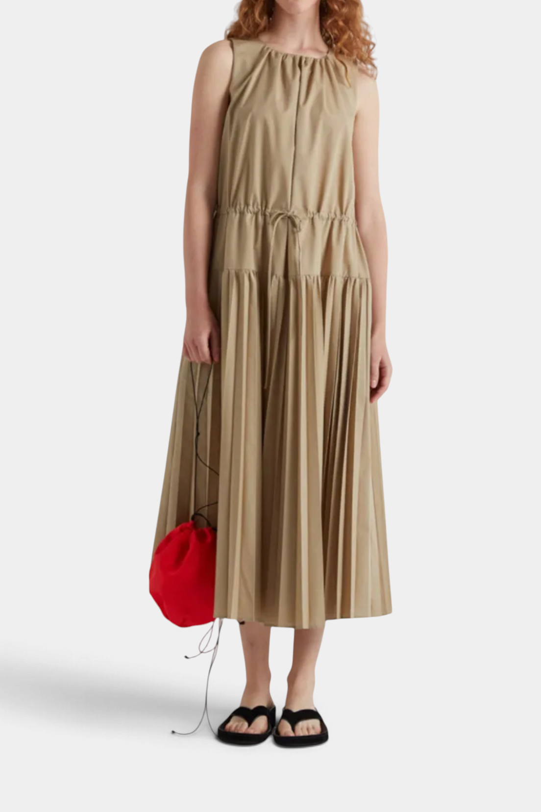 The Copper Shed long beige sleeveless dress with a round neckline, drawstring waist, and pleated midi skirt.