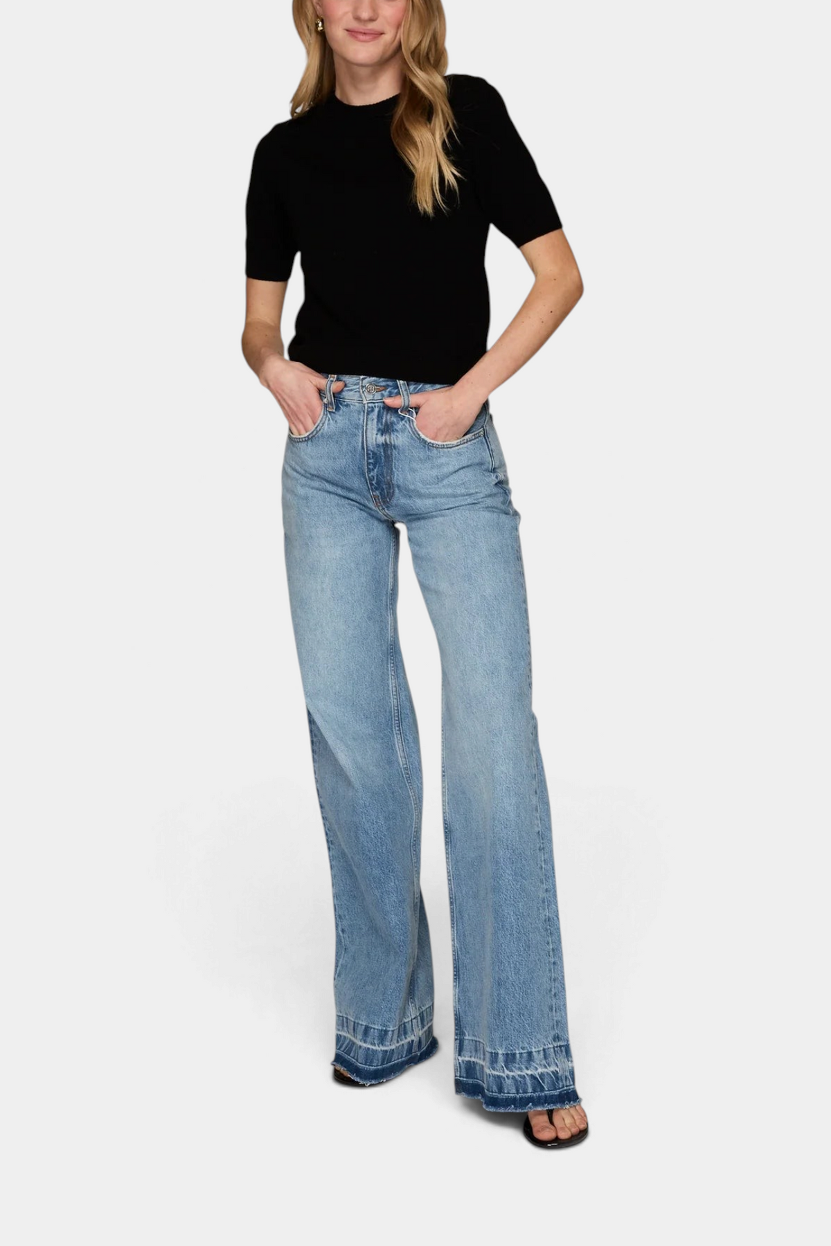The Copper Shed model wearing a black short-sleeve cropped cashmere crew neck sweater with light wash wide-leg jeans.