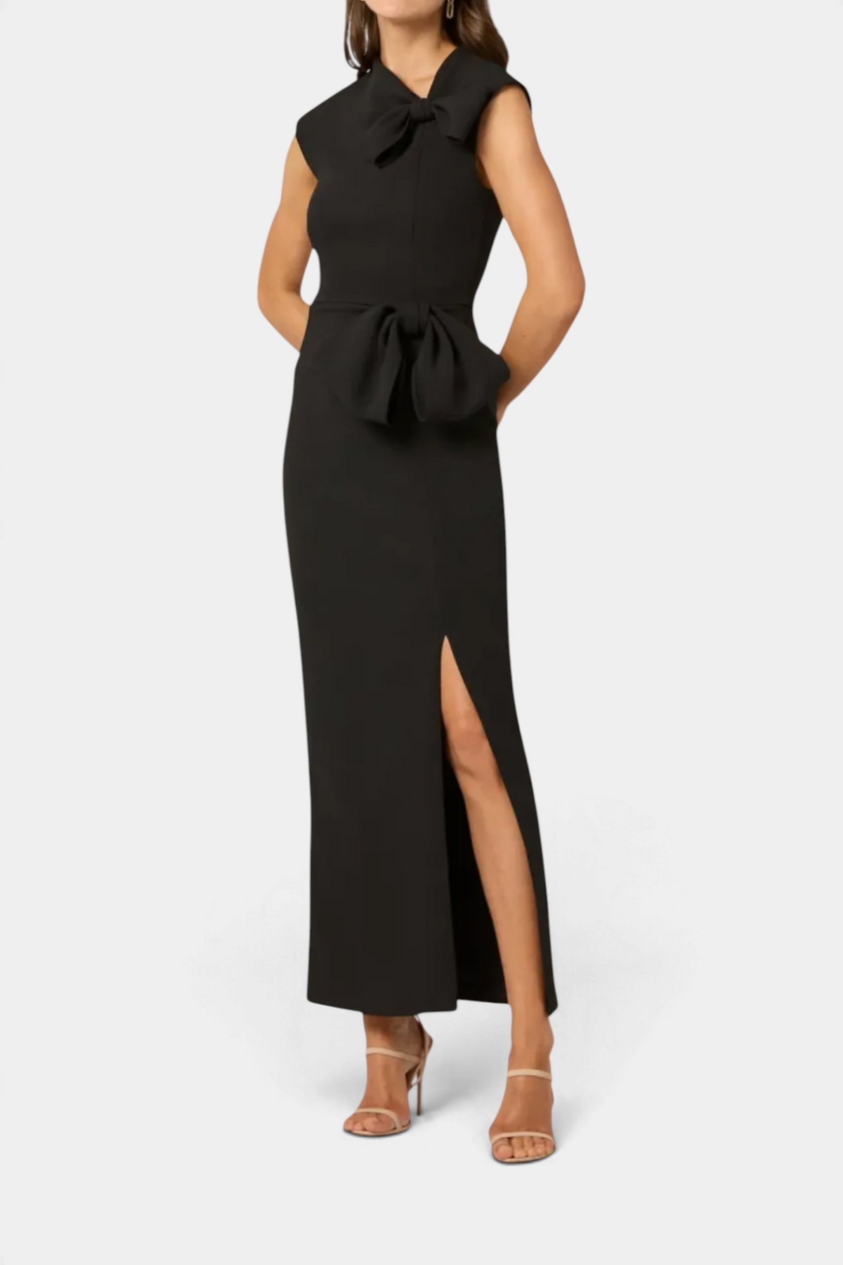 The Copper Shed Midnight Amor black stretch crepe gown with asymmetric neckline, bow details, and side slit skirt.