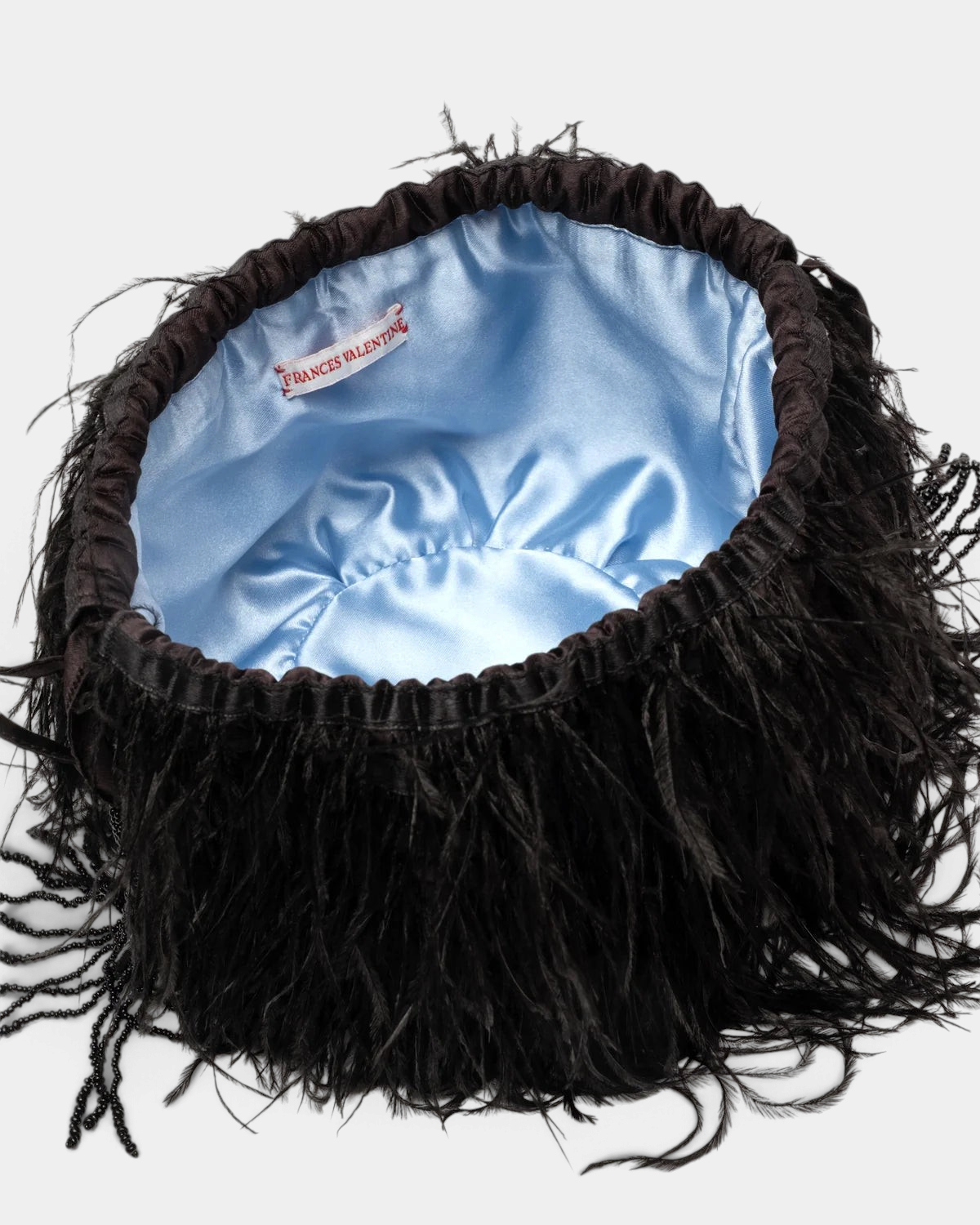 The Copper Shed black faux feather pouf bag with a contrasting light blue satin interior lining