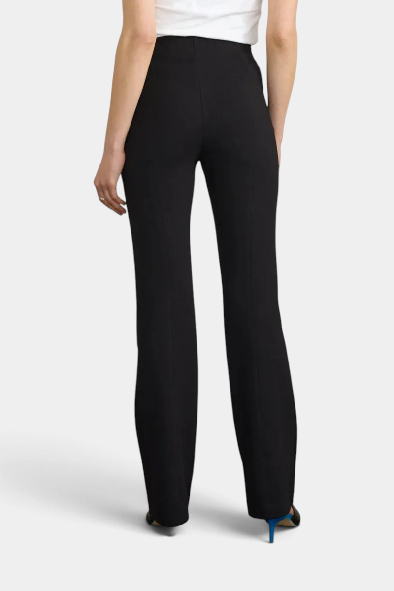The Copper Shed black long flared pants in Japanese Ponte fabric, back view on a model with a white top.