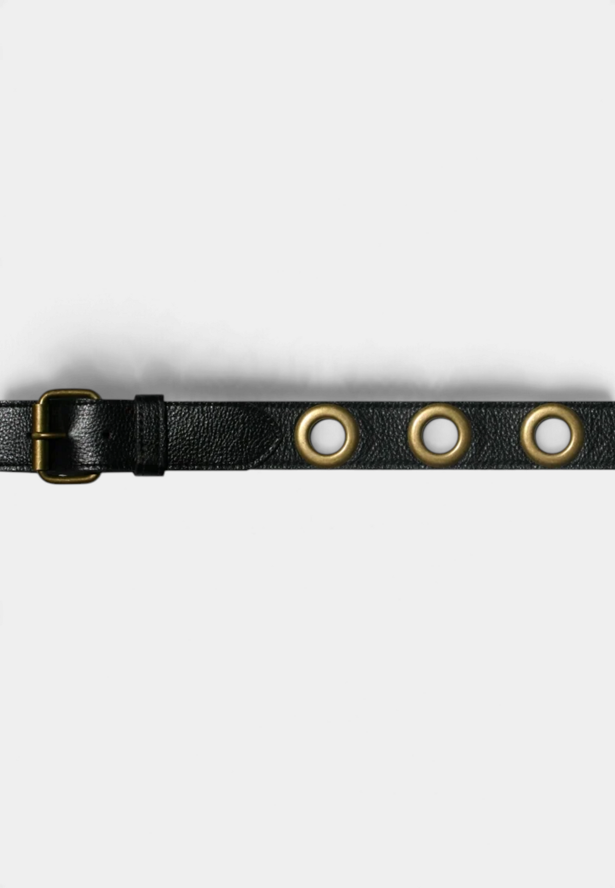 The Copper Shed black leather grommet belt with large gold-tone metal eyelets and a matching gold buckle.