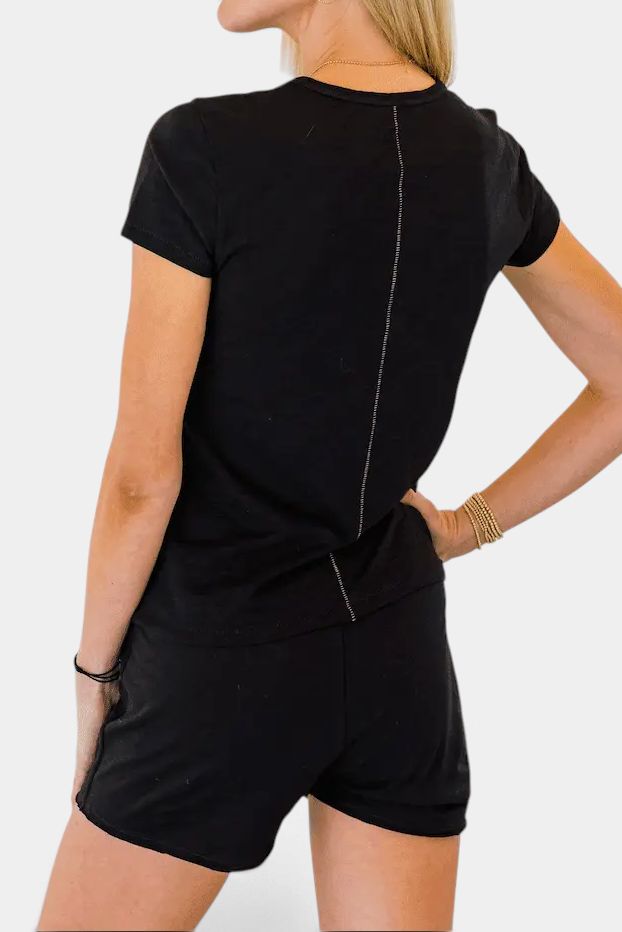 The Copper Shed black Pima cotton lounge shorts with raw edge trim worn by a woman from the back view
