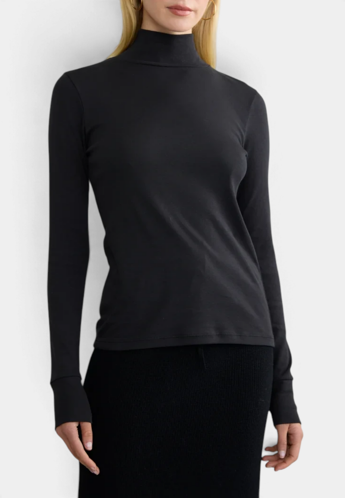 The Copper Shed black long sleeve ribbed organic cotton turtleneck worn by a blonde model against a white background.