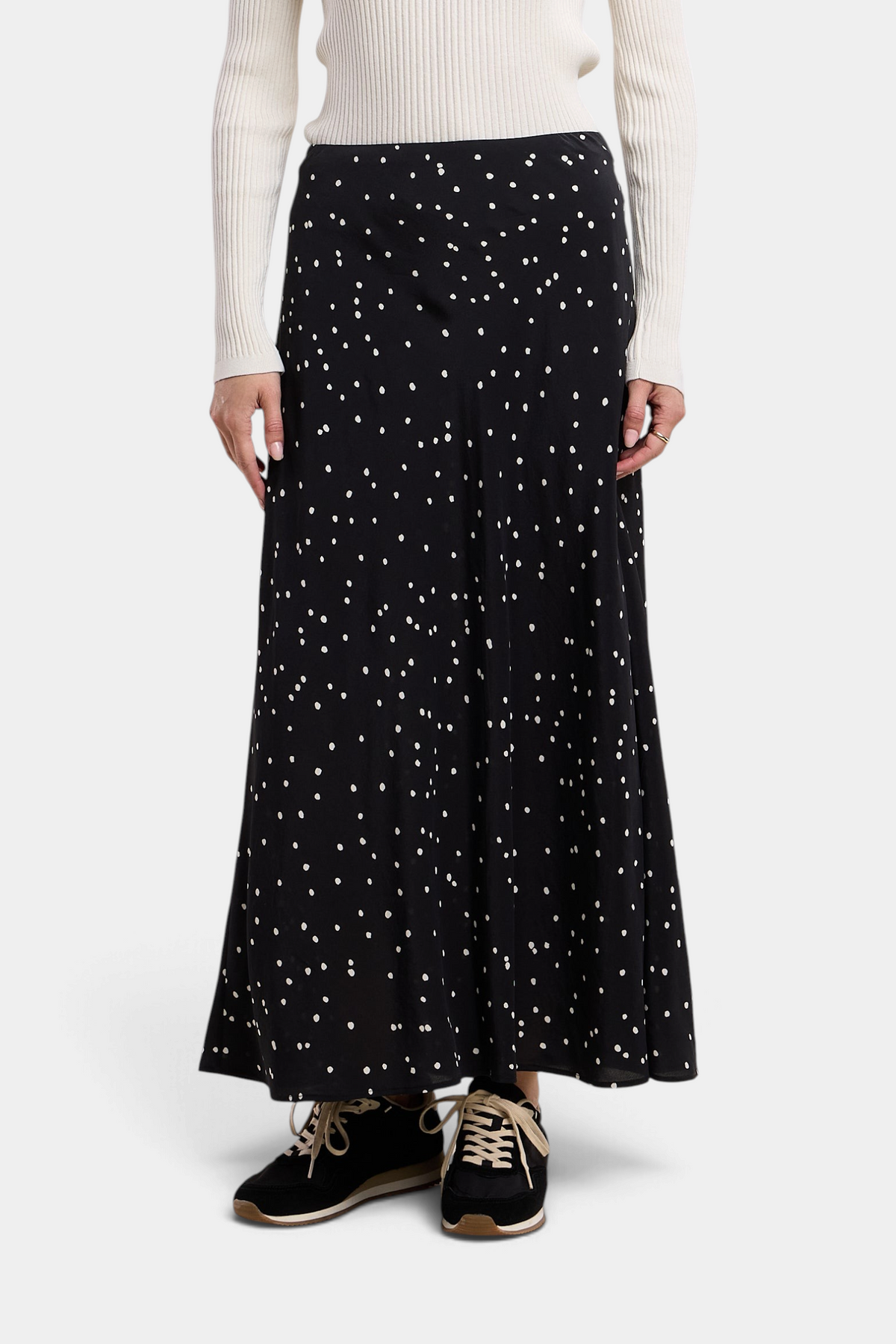 The Copper Shed Cadence black silk maxi skirt with white polka dots, featuring an A-line silhouette and elastic waist.