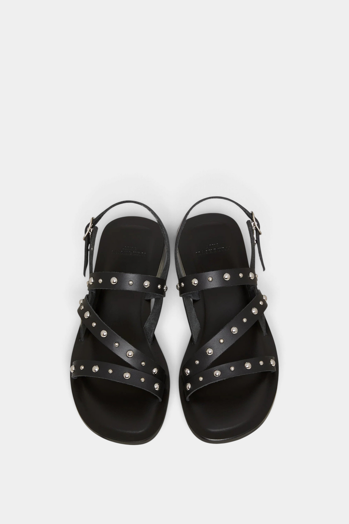 Black sandals with studded details on a light gray background