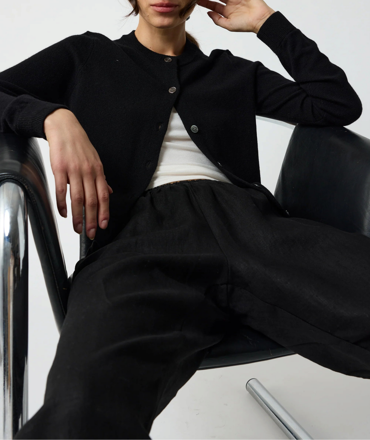 The Copper Shed black crew neck wool blend cardigan with button-down front and raglan sleeves worn by a model.
