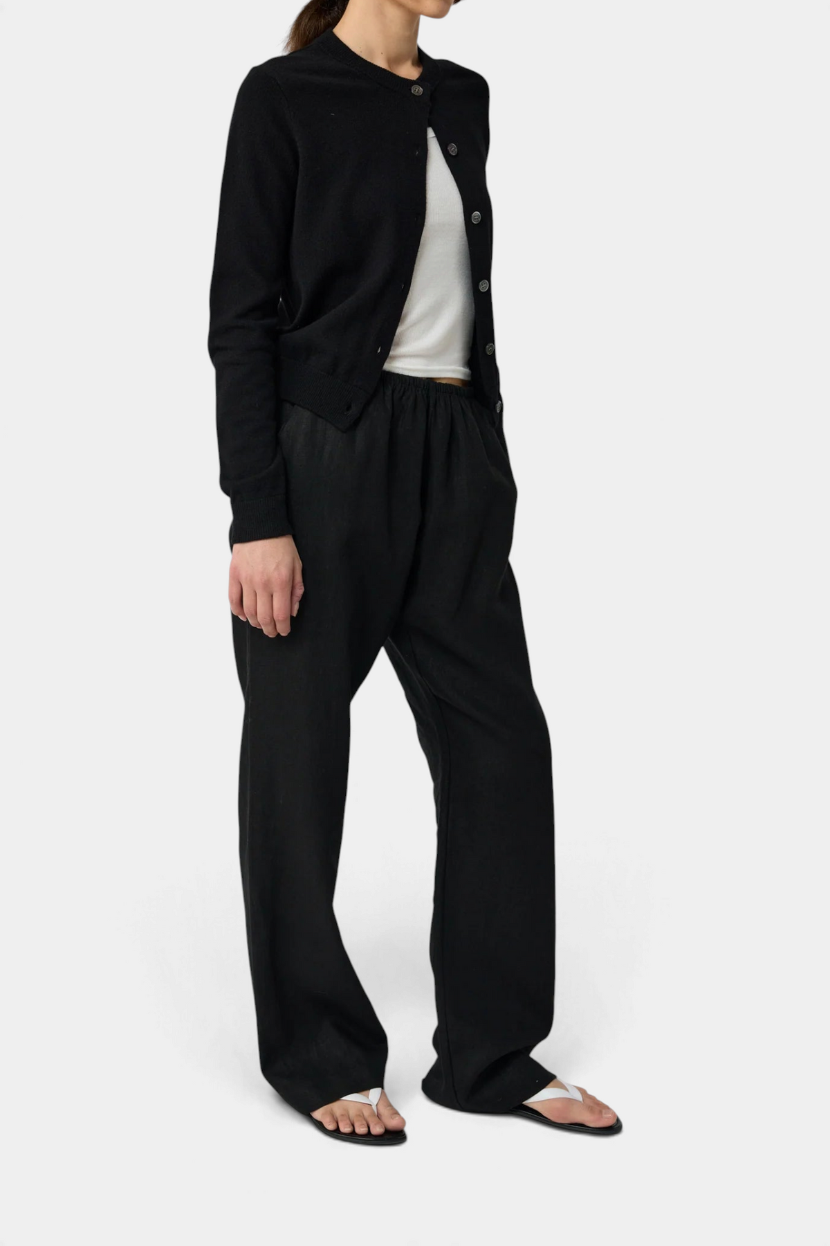 The Copper Shed black wool blend crew neck cardigan with button front and raglan sleeves worn with matching trousers.