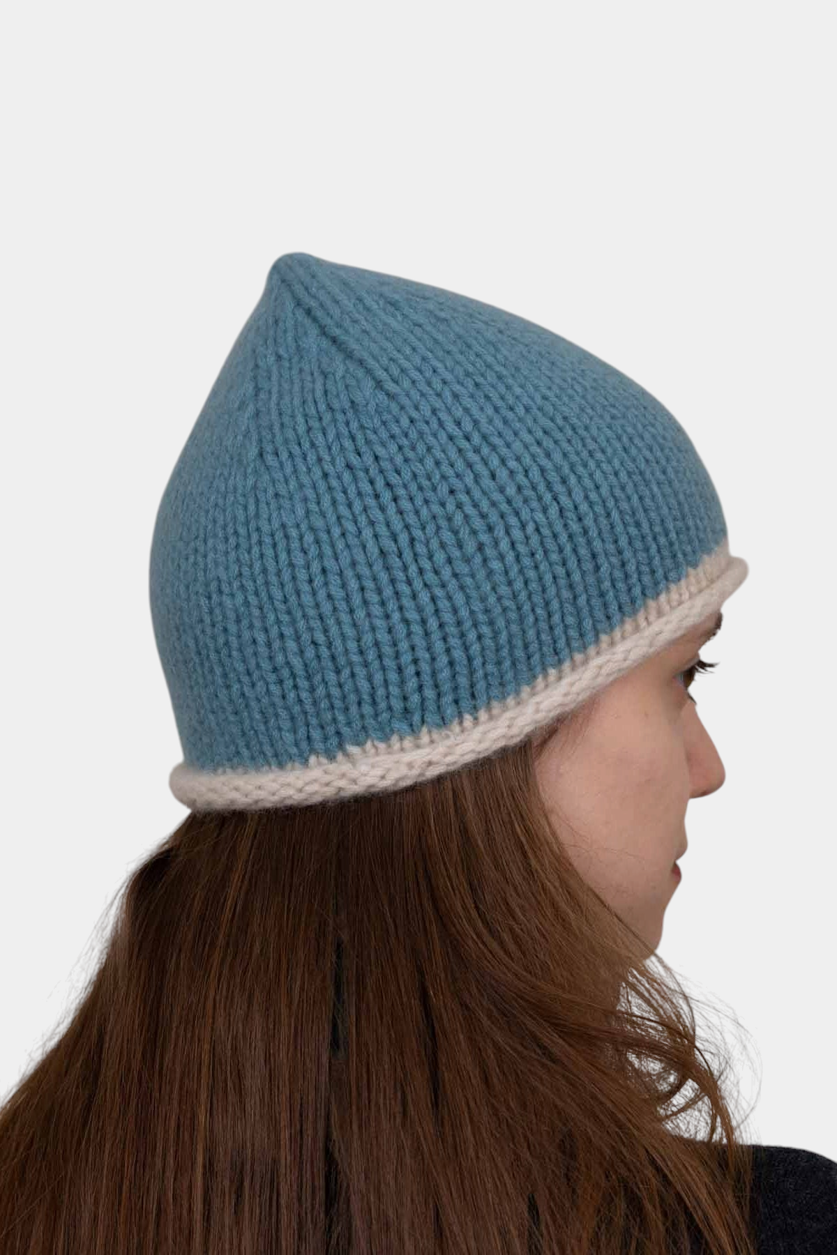 The Copper Shed blue and cream hand-knitted organic cashmere beanie with a relaxed rolled edge on a model