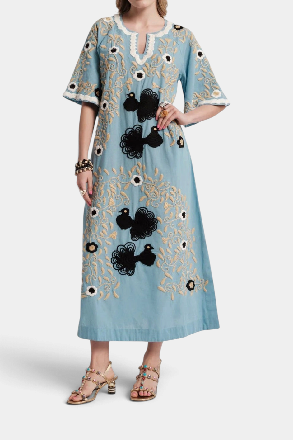 The Copper Shed light blue cotton maxi caftan with black and cream peacock embroidery, bell sleeves, and side pockets.
