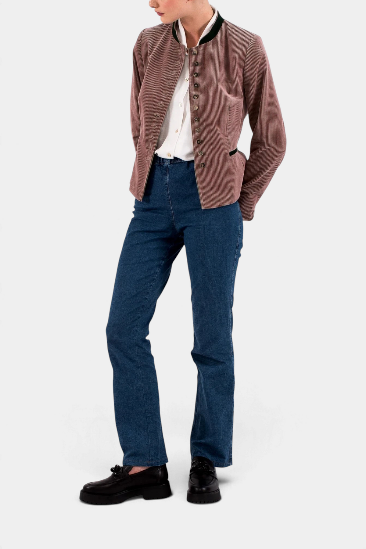 The Copper Shed women's brown corduroy blazer with a high collar, worn over a white shirt and blue jeans.