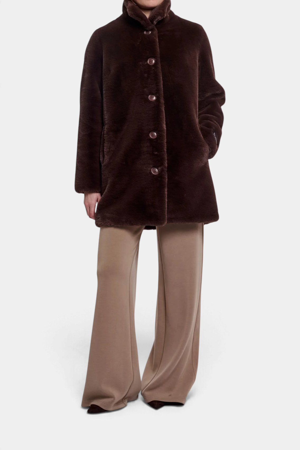 The Copper Shed Nonna coat in dark brown faux fur with a high-neck collar, button-up front, and side pockets.