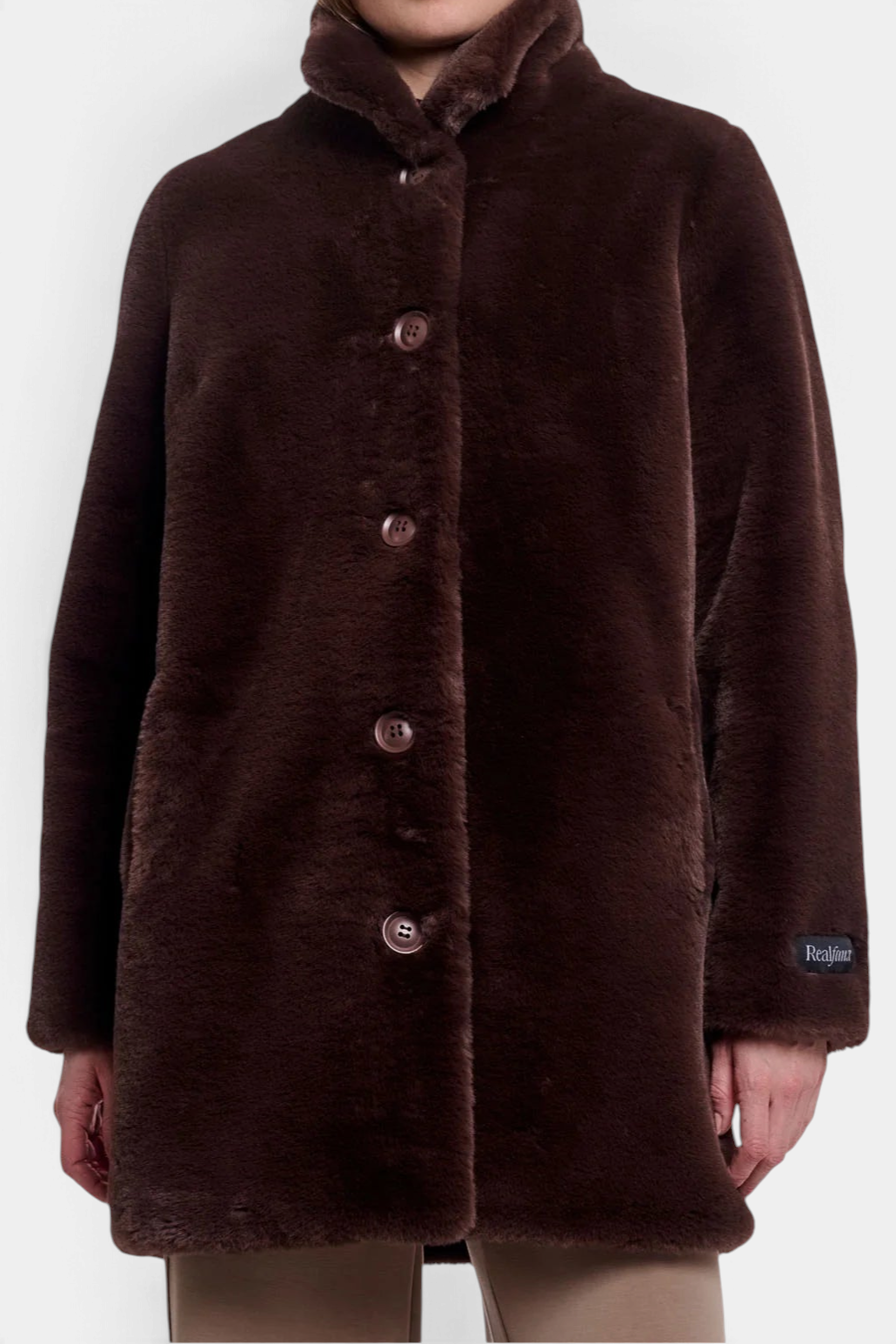 The Copper Shed Nonna coat in dark brown faux fur with a high-neck collar, button-up front, and sleeve label detail.
