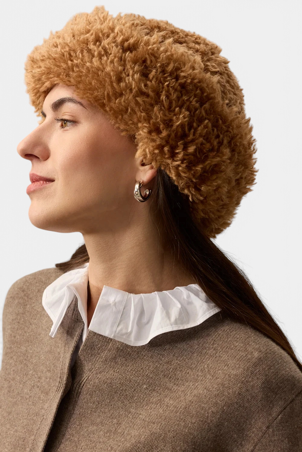 The Copper Shed brown faux sheepskin sherpa hat with a deep brim worn by a woman in profile.