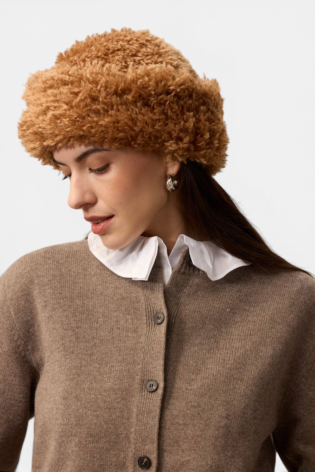 The Copper Shed brown faux sheepskin sherpa hat with a deep brim worn by a woman in a brown cardigan.