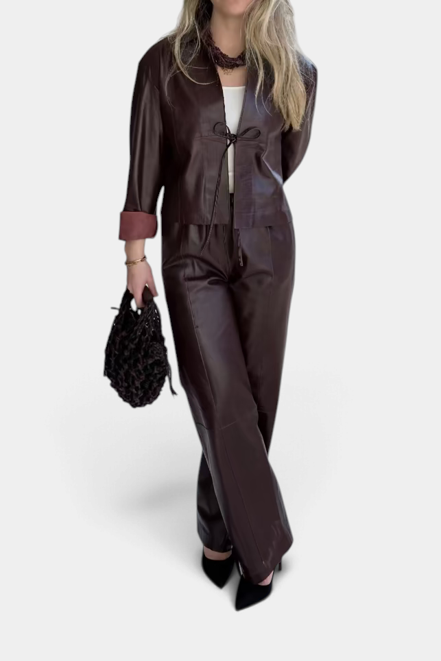 The Copper Shed short dark brown leather jacket with classic collar, drawstring front, and flared sleeves on a model